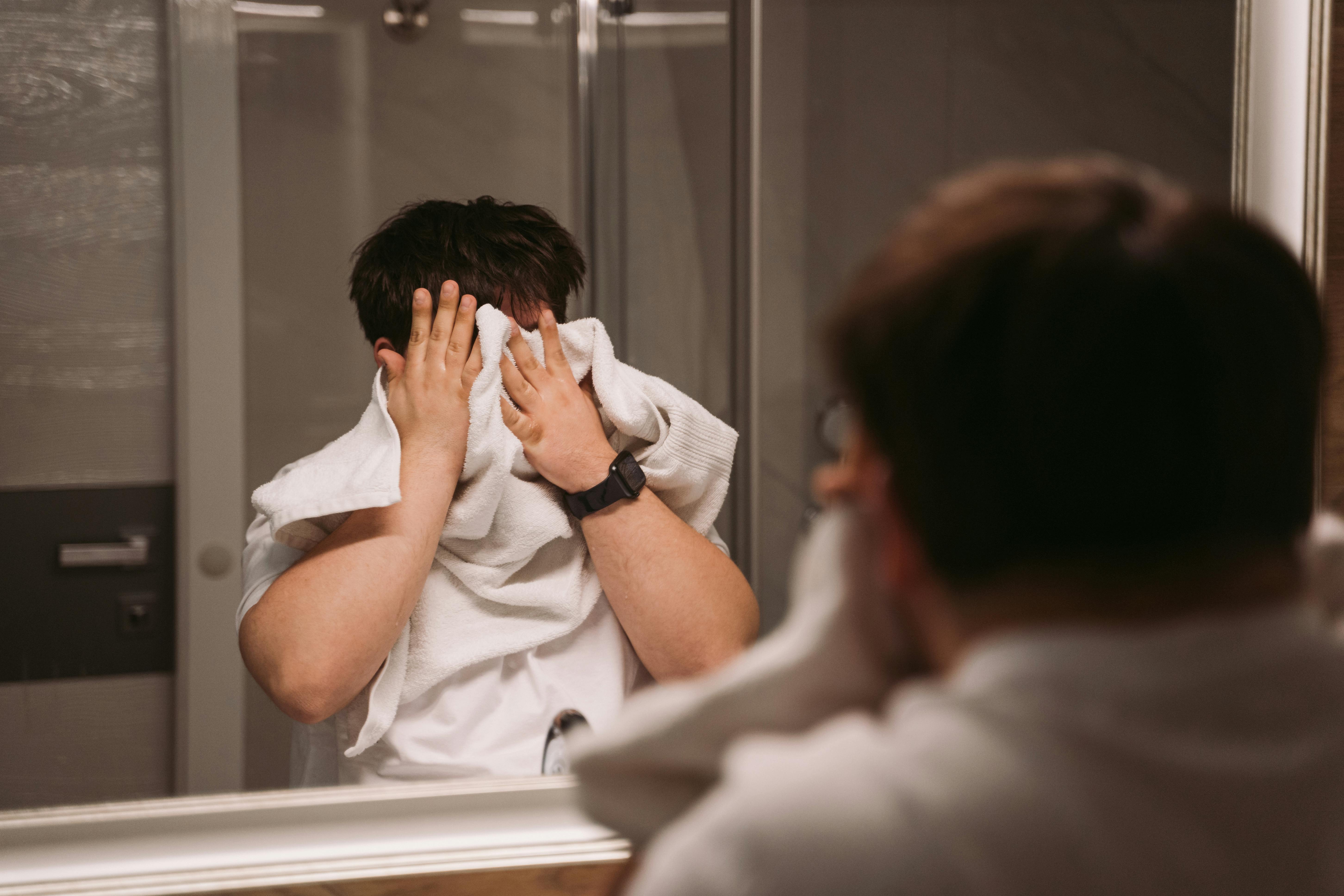 A man wiping his face with a towel | Source: Pexels