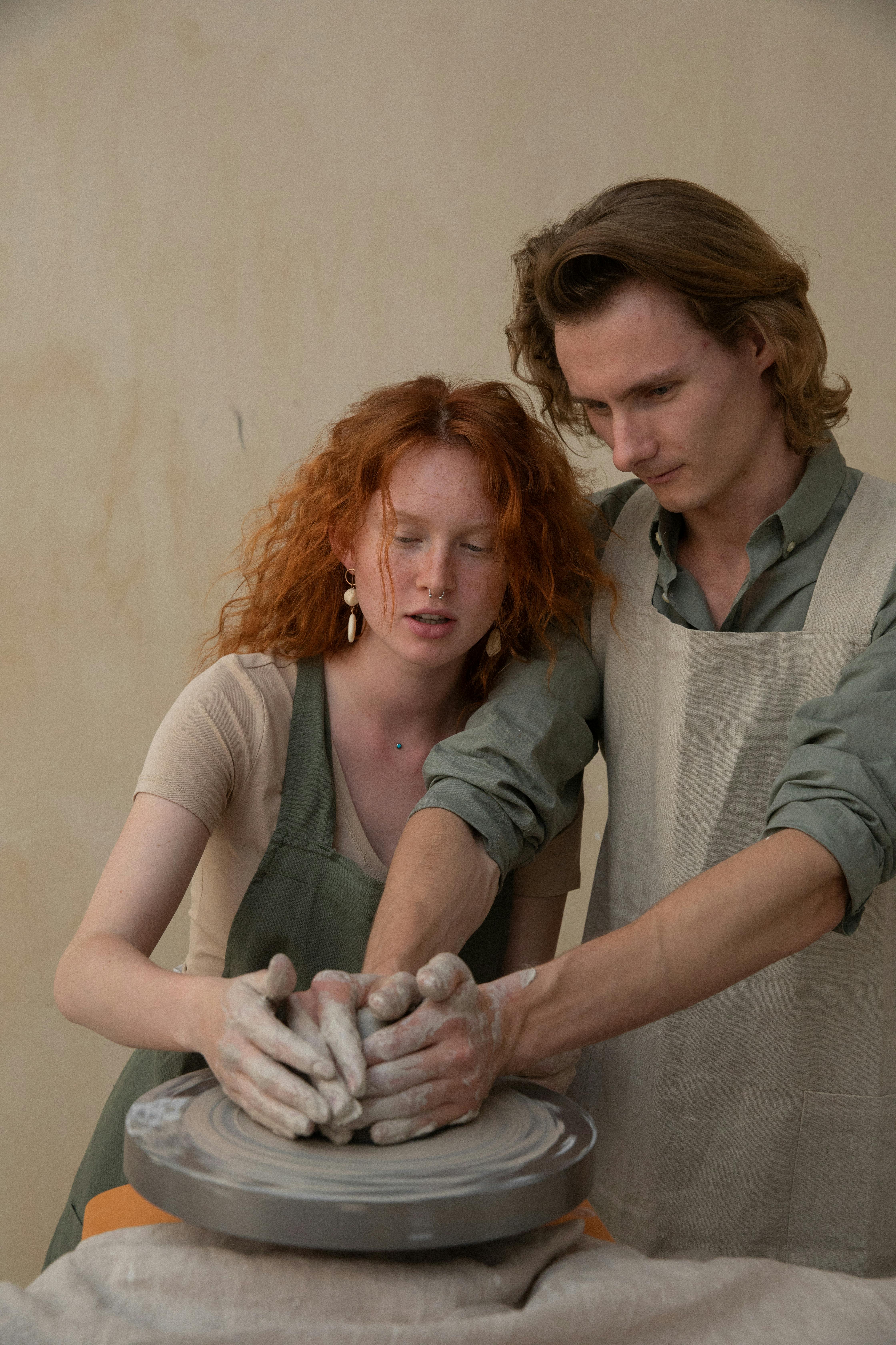 A couple working together at a pottery wheel | Source: Pexels