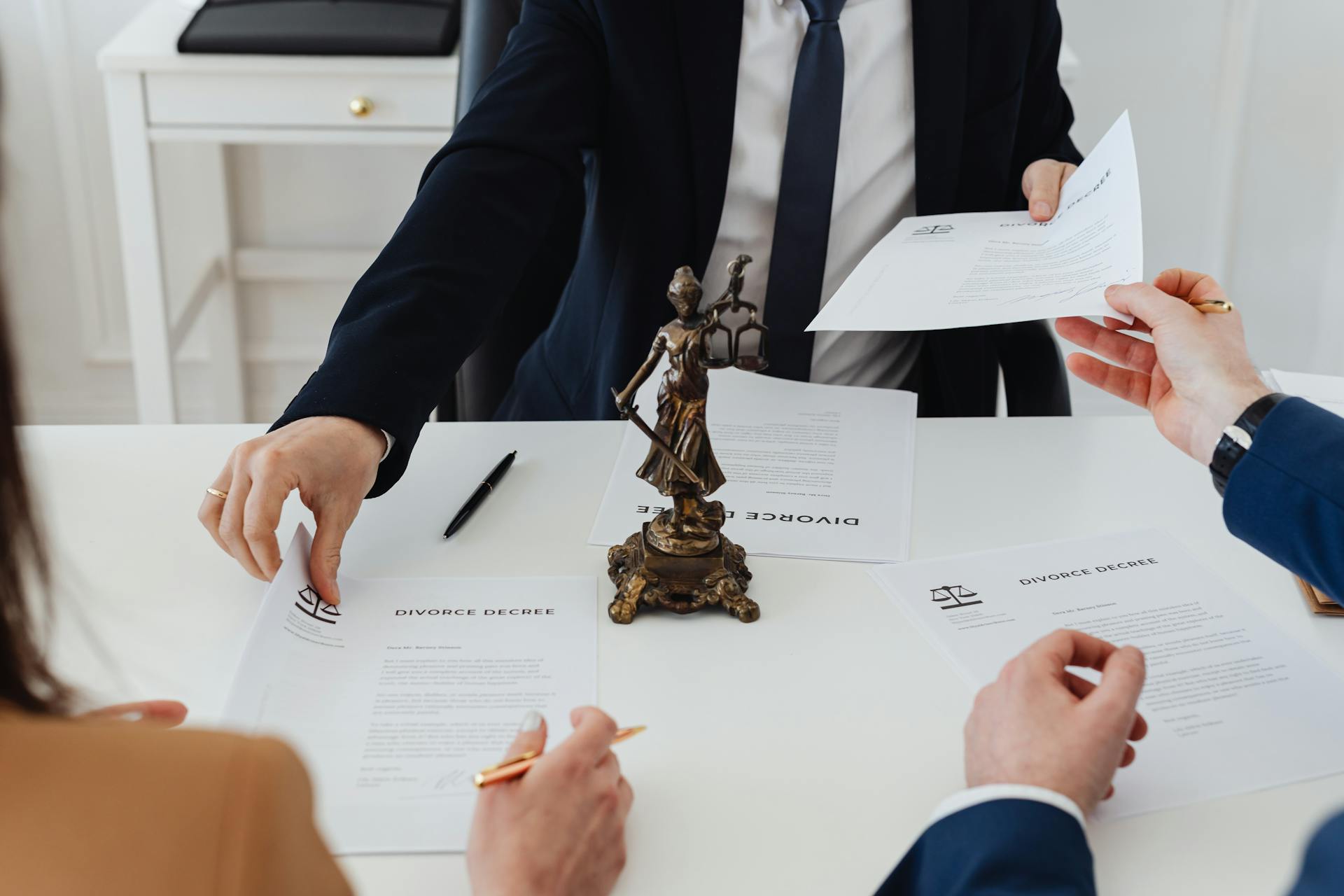 A couple signing their divorce papers in a lawyer's office | Source: Pexels