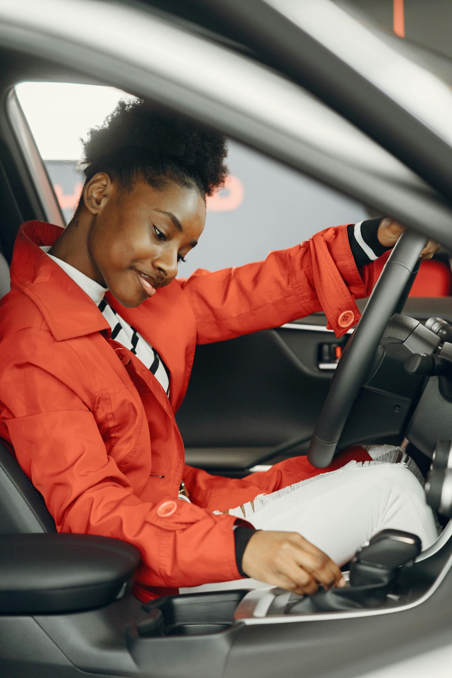 A woman smiling while driving | Source: Pexels