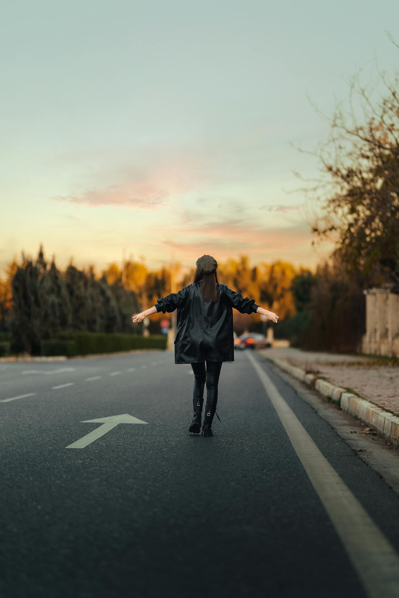 A woman standing on the road with her arms outstretched | Source: Pexels