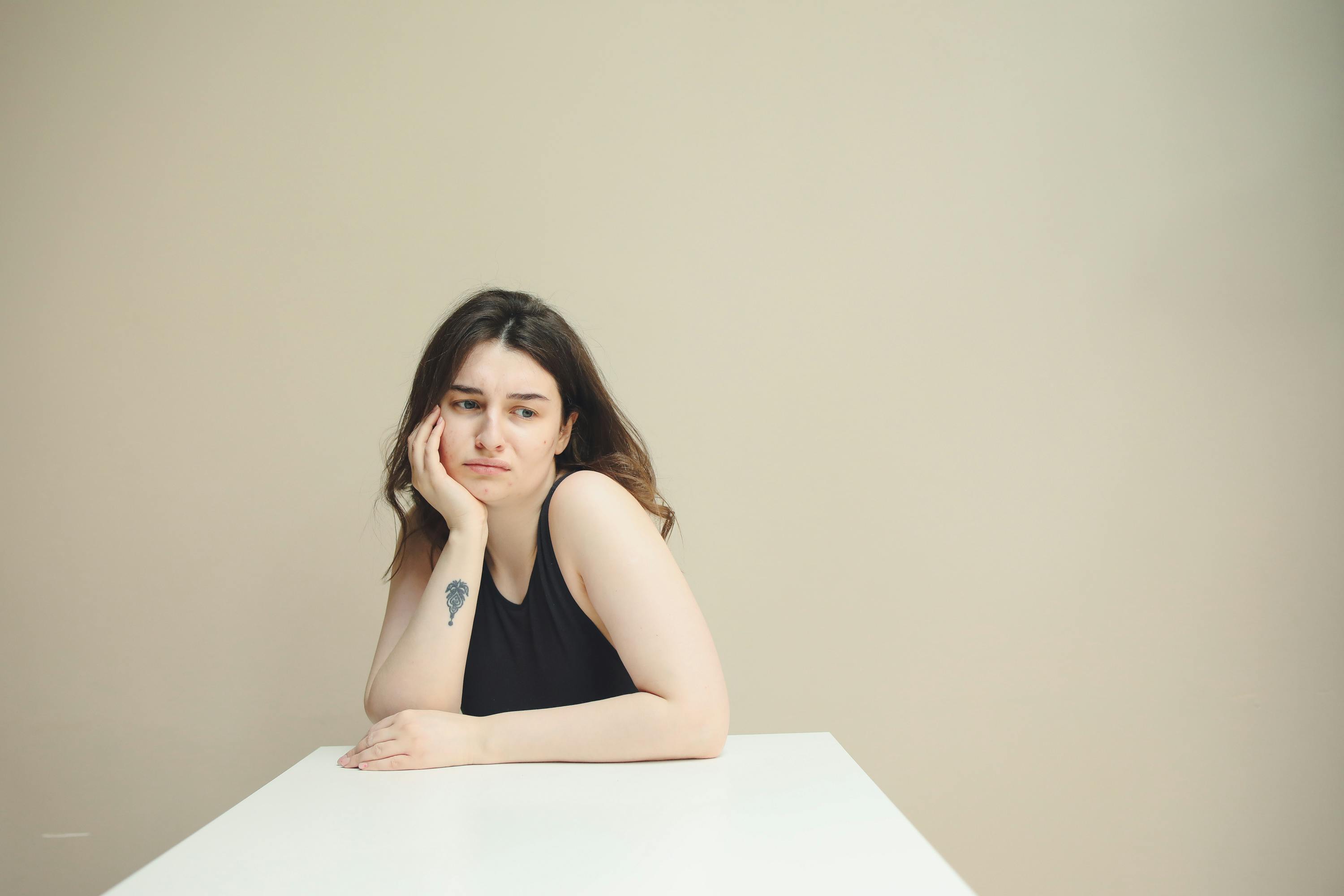 A pensive woman sitting at a table | Source: Pexels