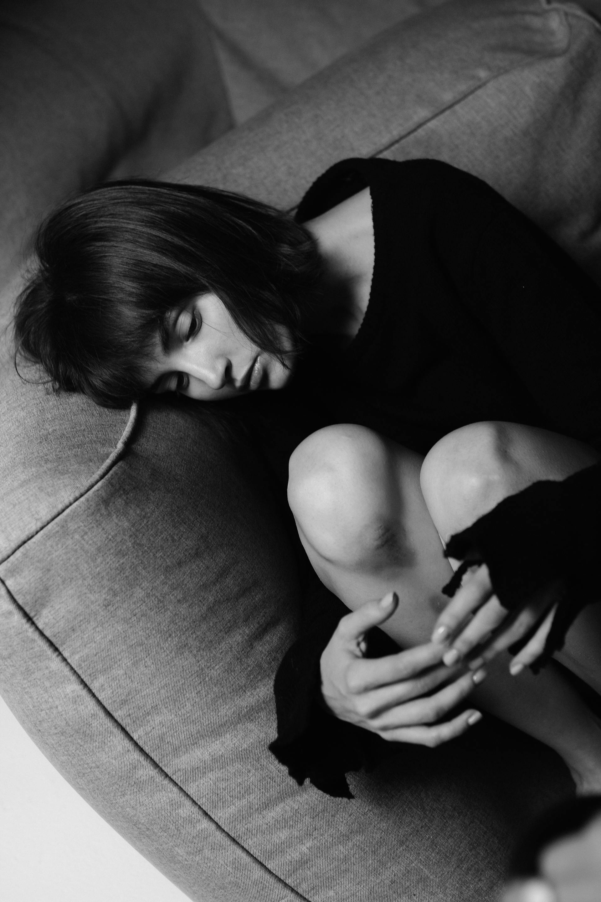 Grayscale photo of a woman lying on the couch | Source: Pexels