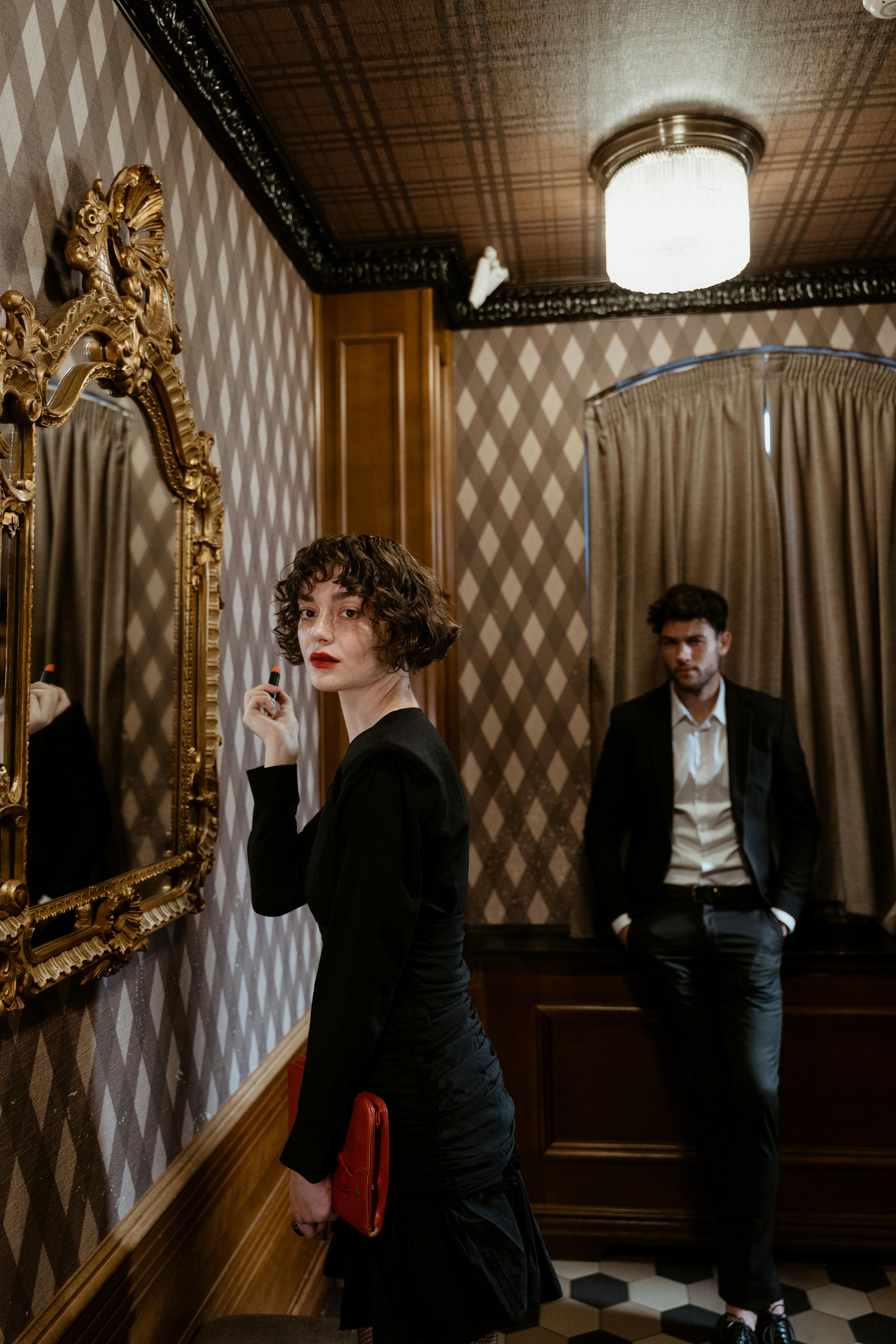 A man watching a woman putting on lipstick | Source: Pexels