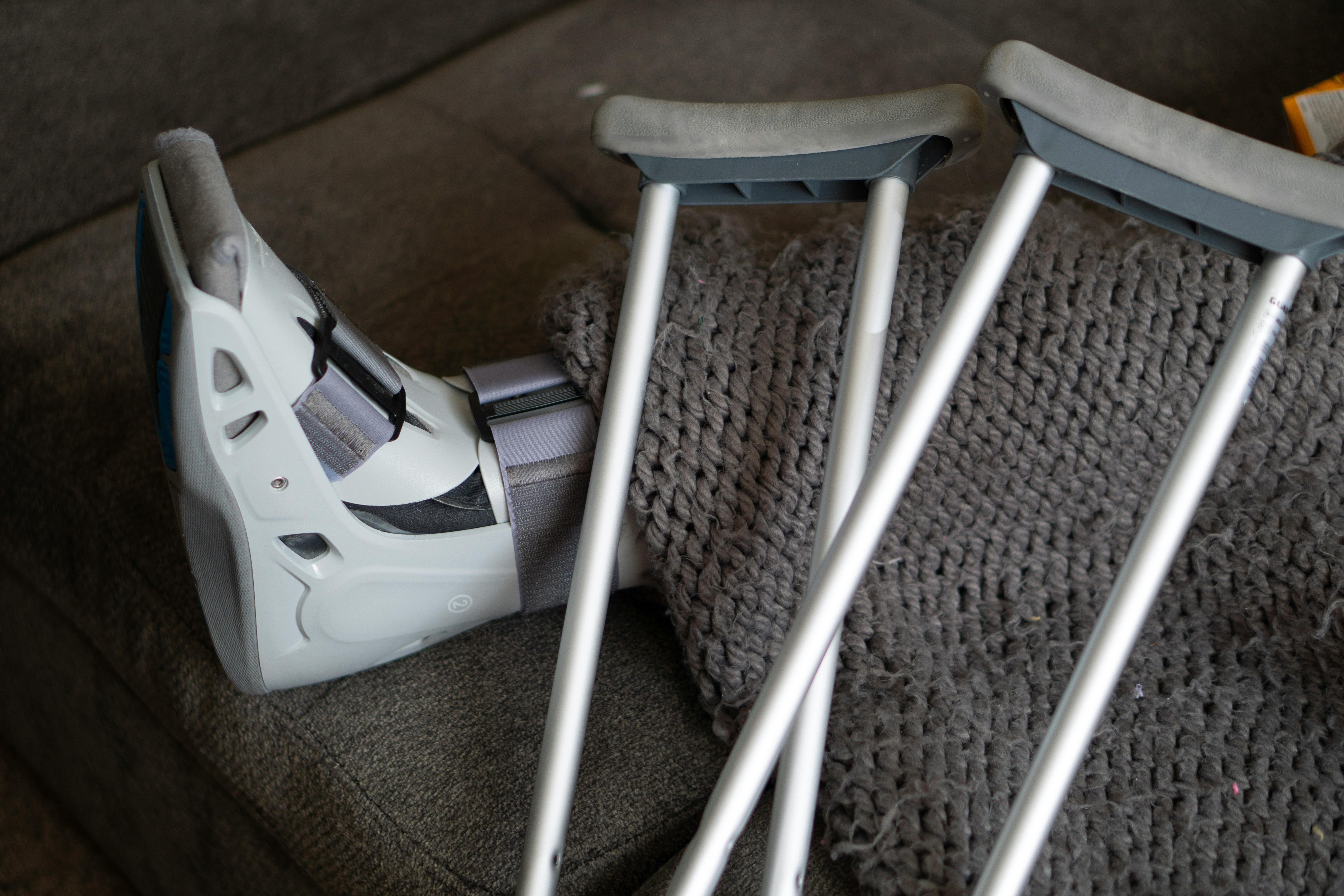 A person in a moonboot and a pair of crutches | Source: Pexels
