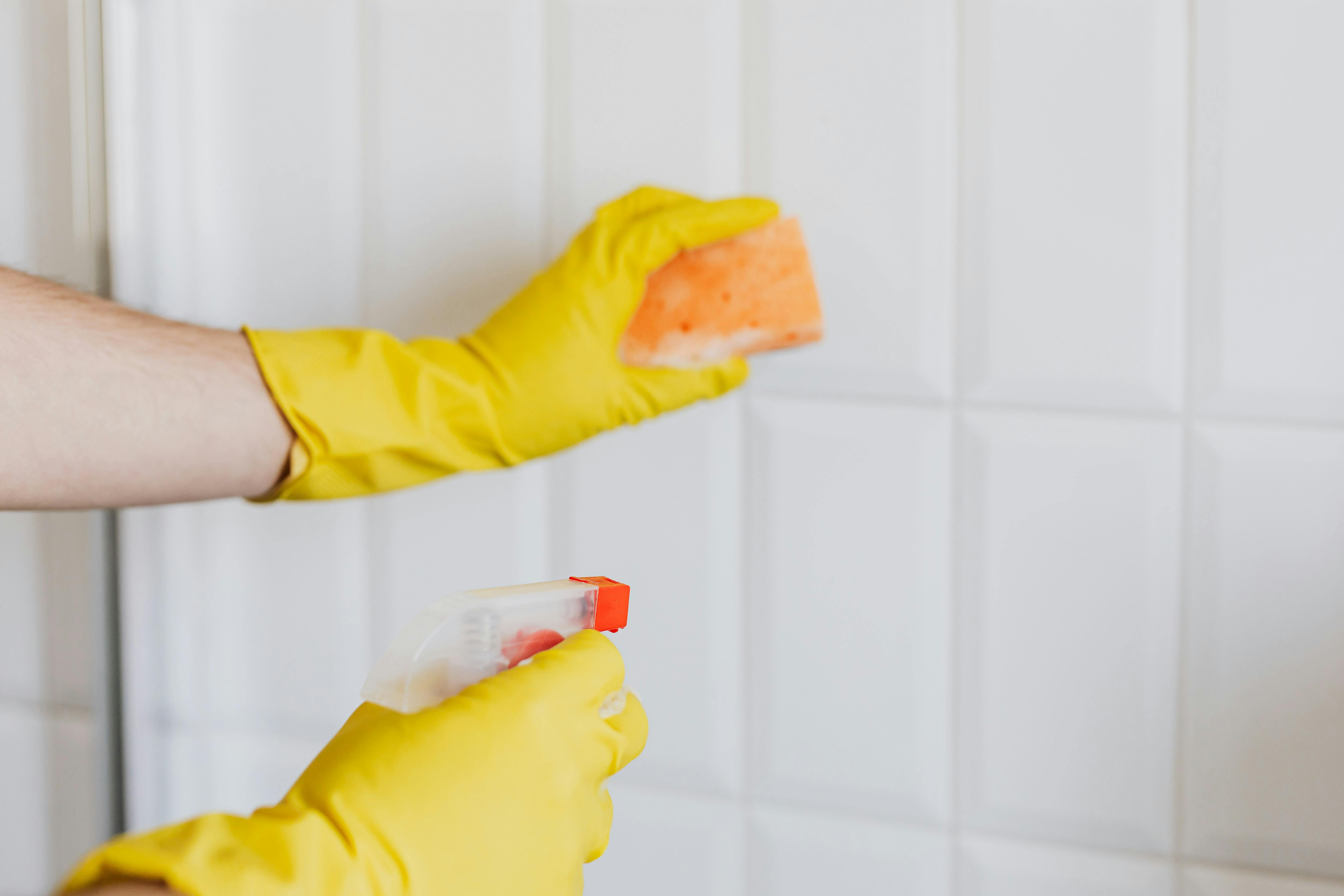 A person cleaning a bathroom wearing yellow gloves | Source: Pexels