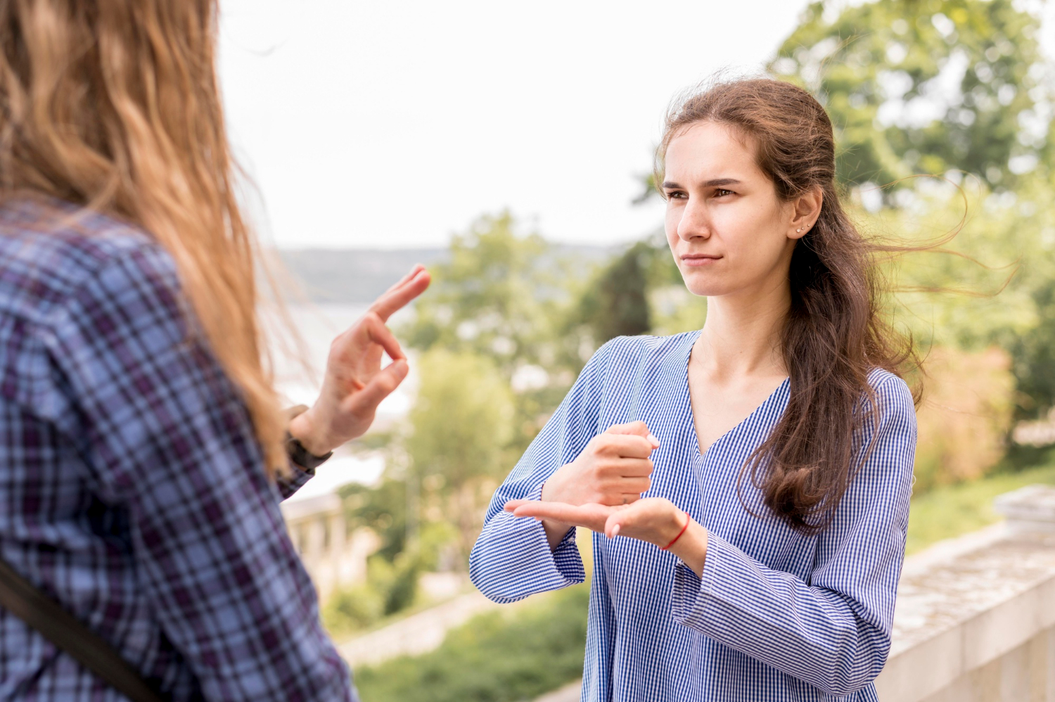 Two women communicating through sign language | Source: Freepik