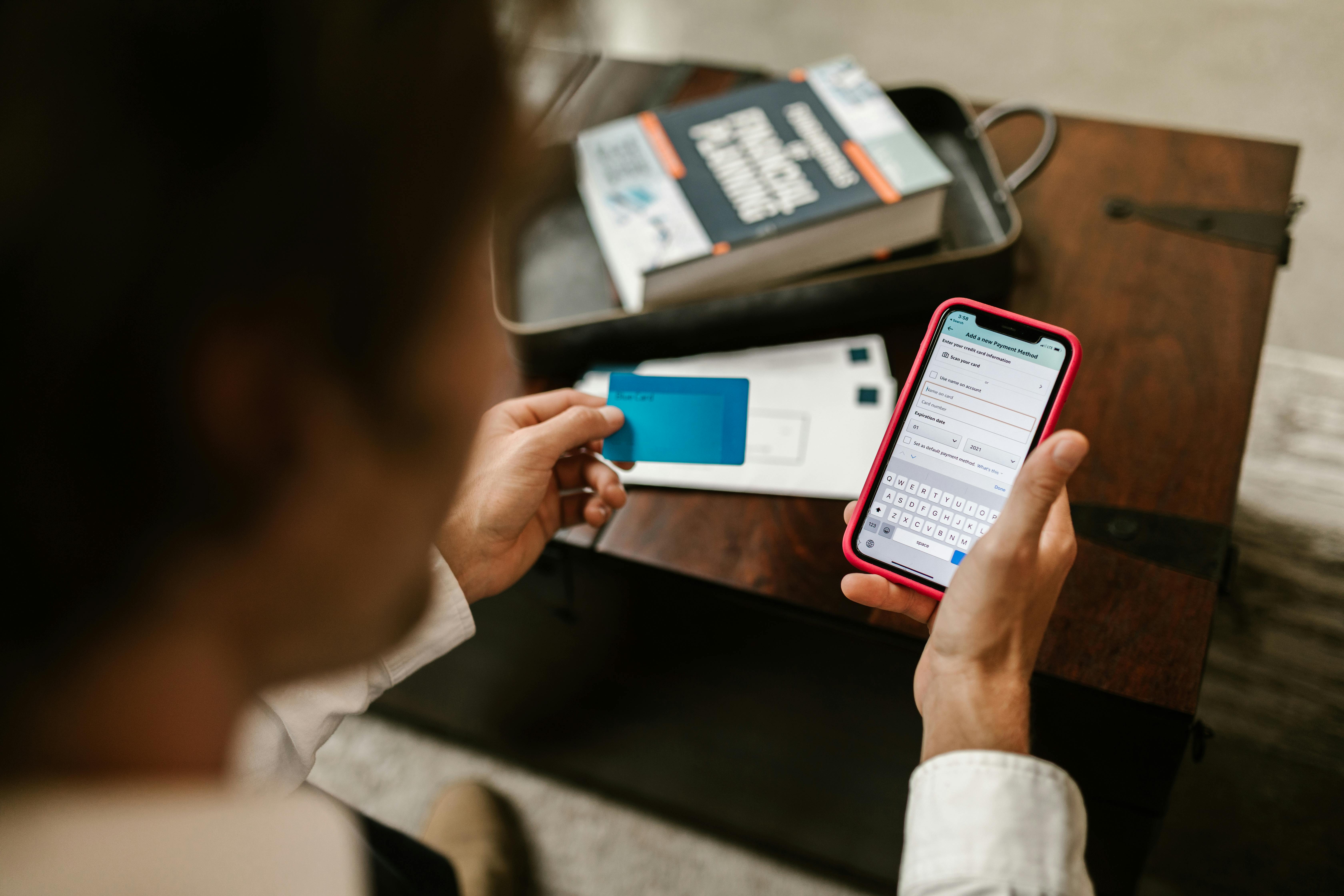 A person holding a bank card and a cellphone | Source: Pexels