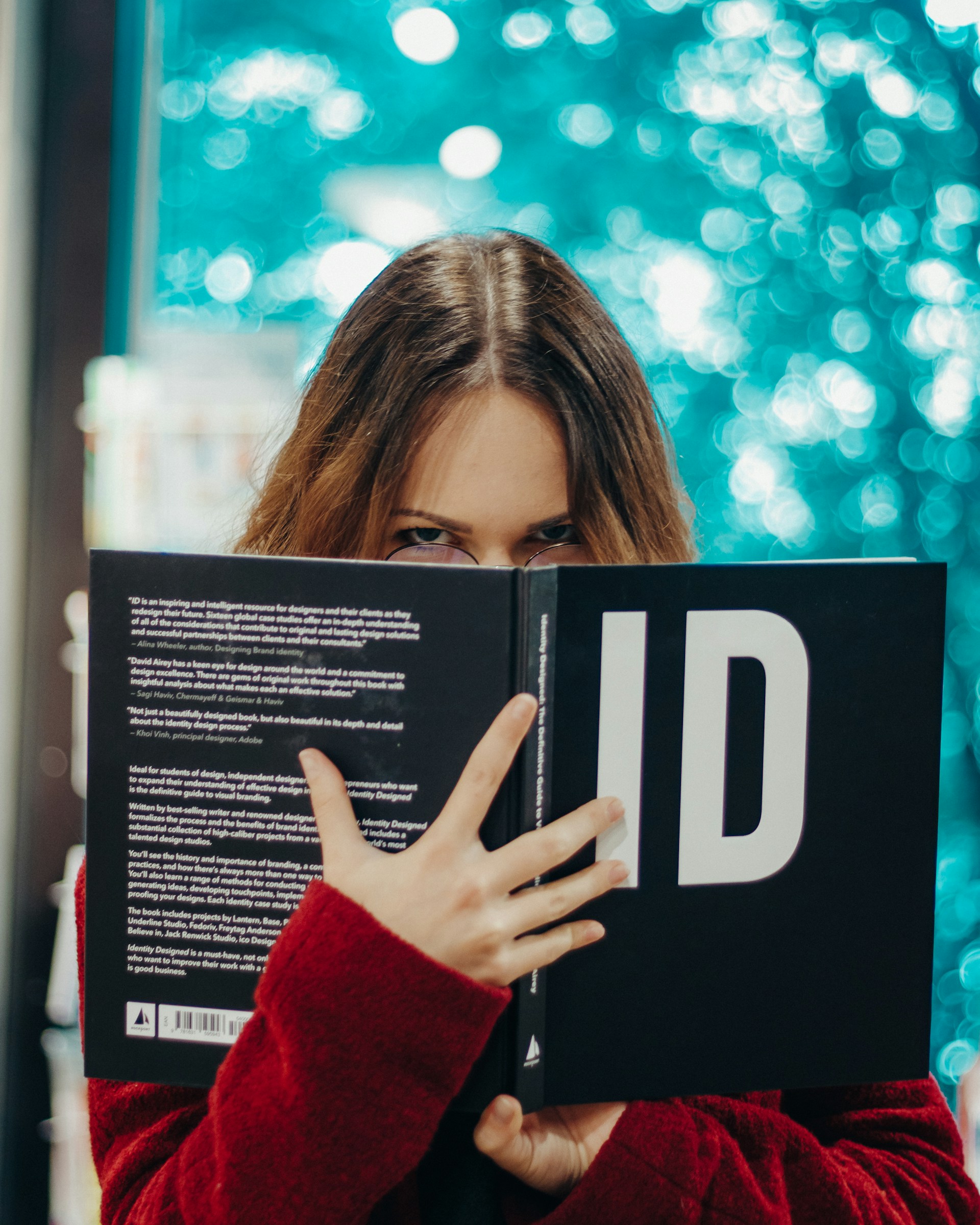 A young woman holding a book and staring | Source: Unsplash
