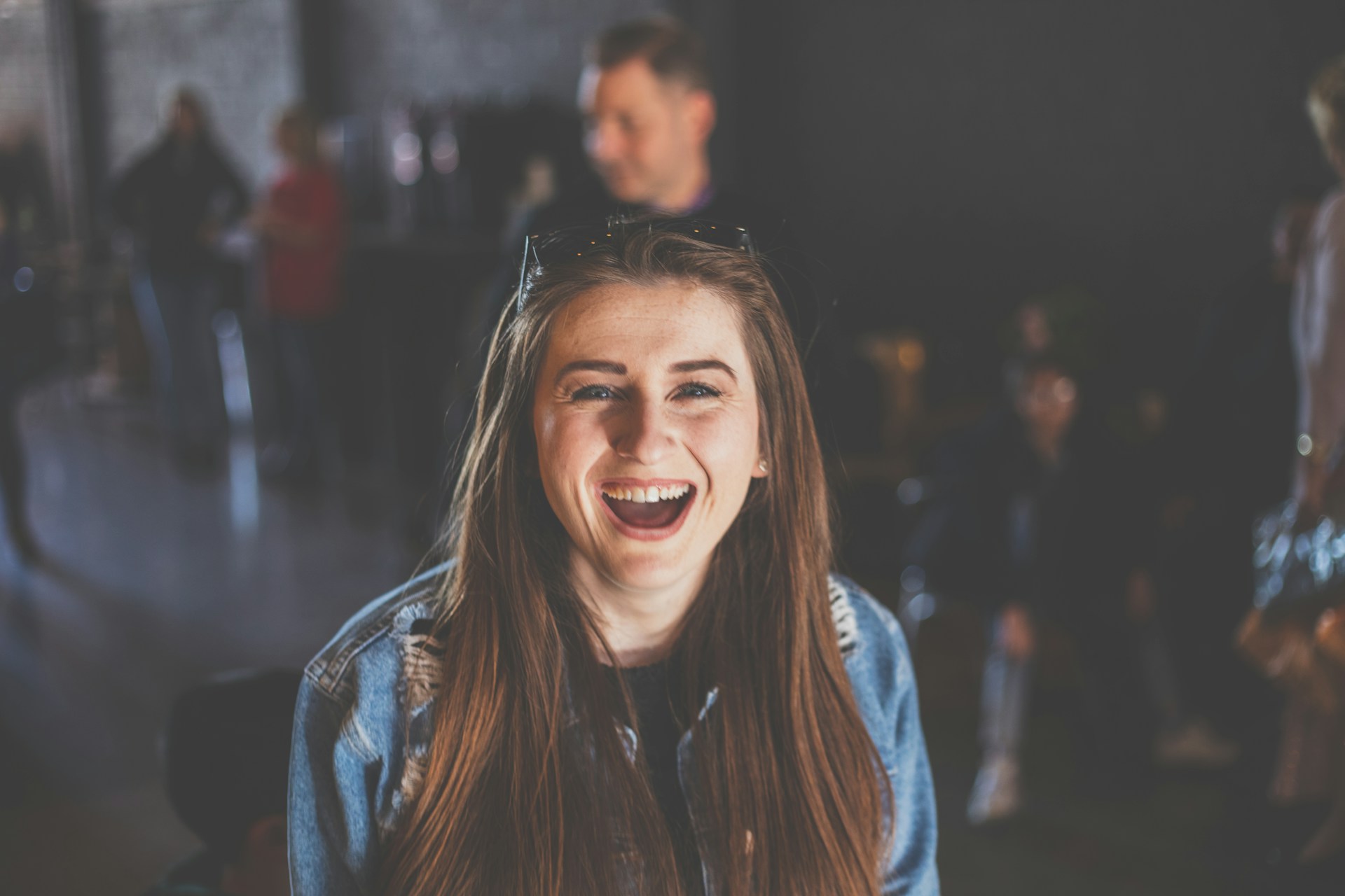Uma adolescente em uma loja olhando para algo com alegria | Fonte: Unsplash