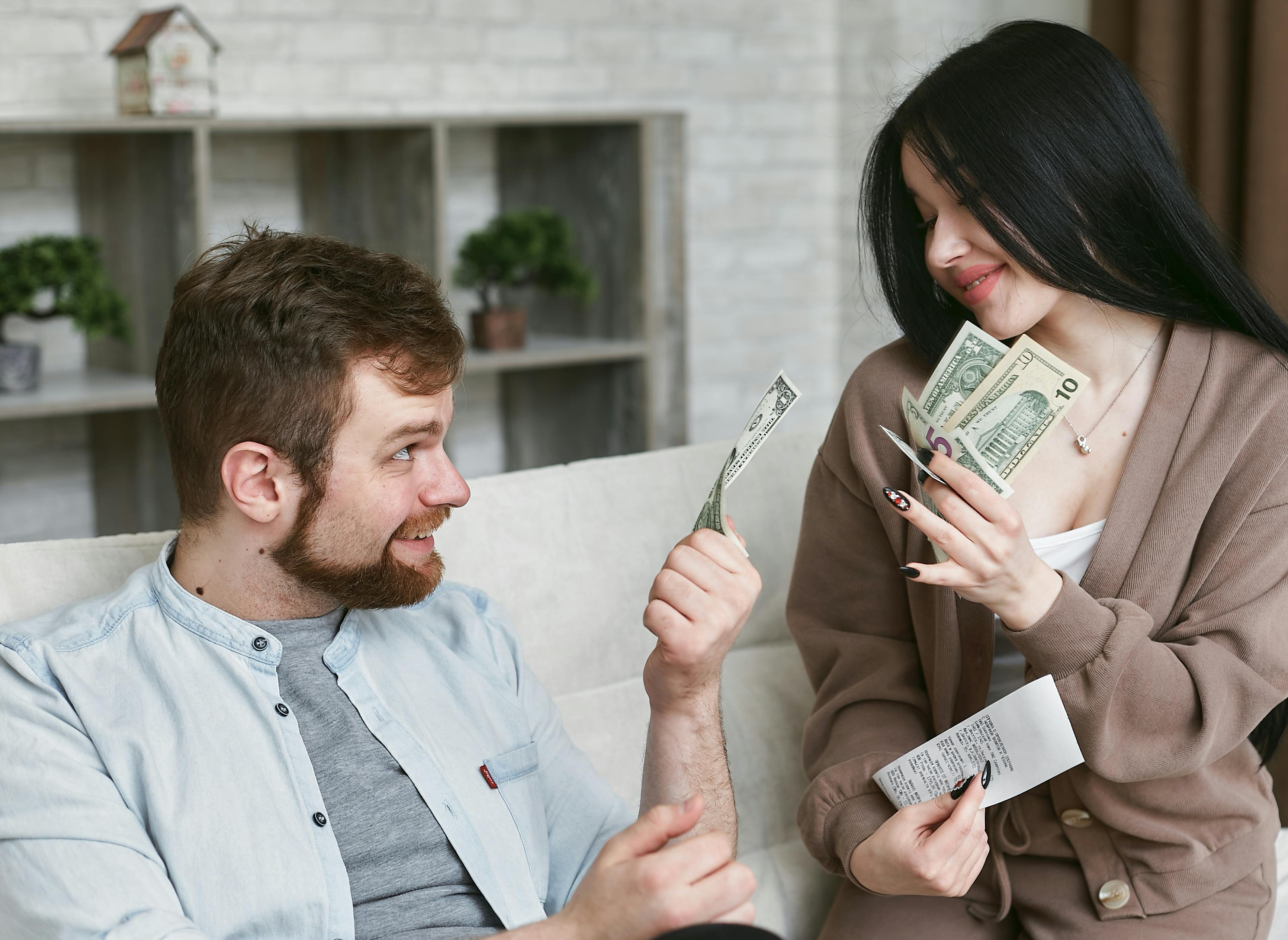 A man and a woman holding money | Source: Pexels