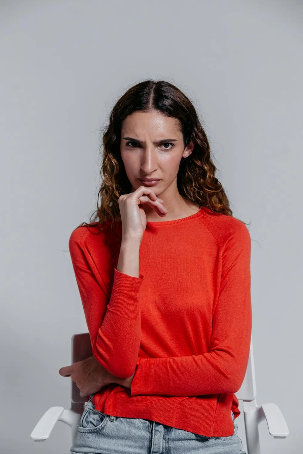 A frowning woman in a red sweater | Source: Pexels