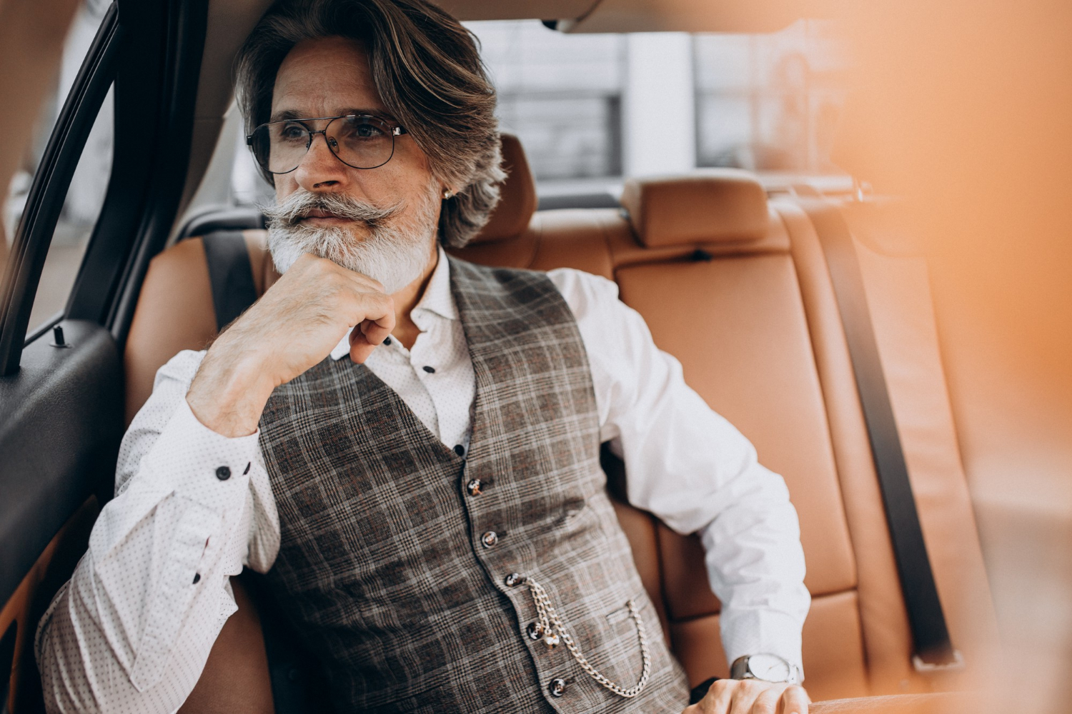 An elegant senior man sitting in his car | Source: Freepik