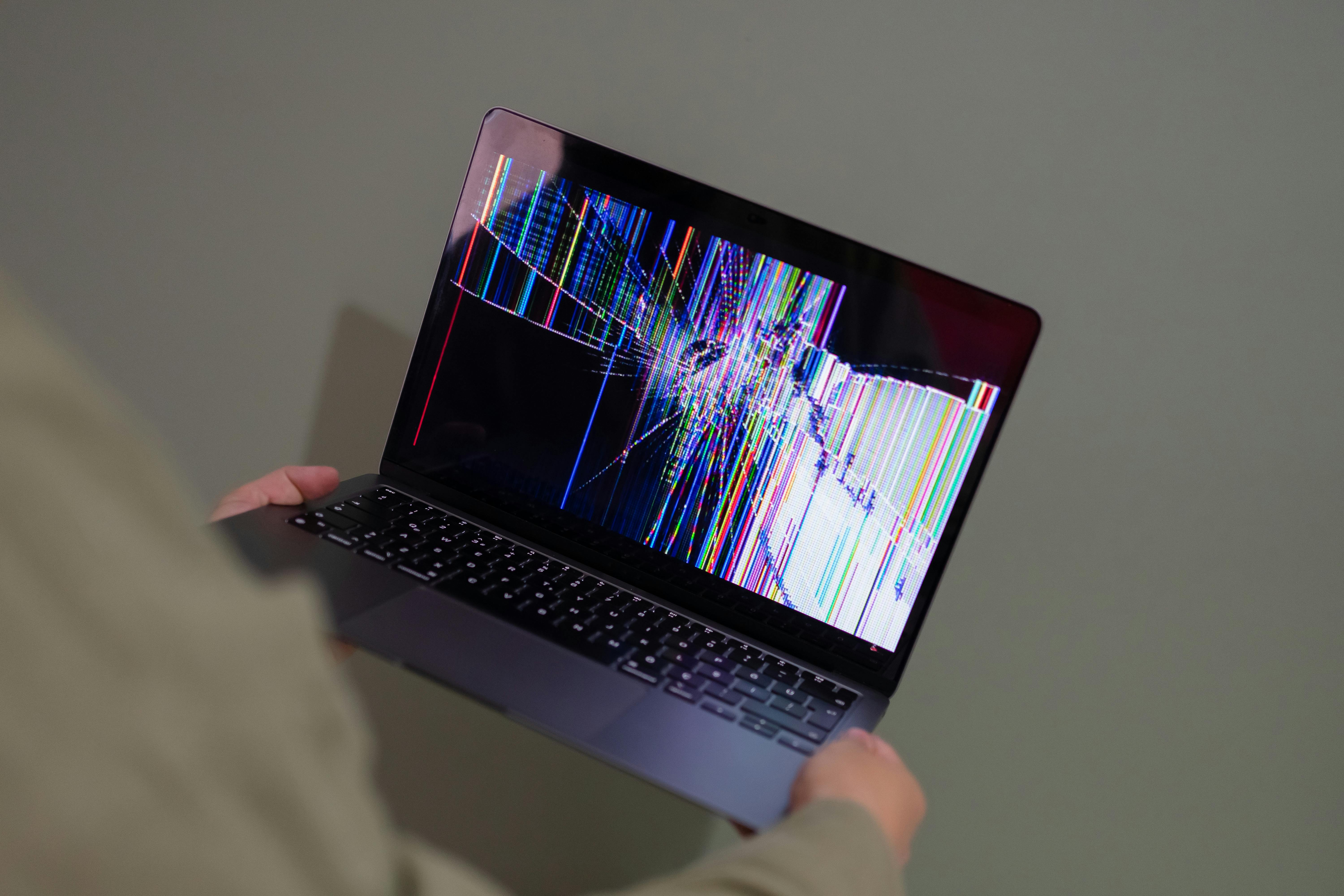 A person holding a broken laptop | Source: Pexels