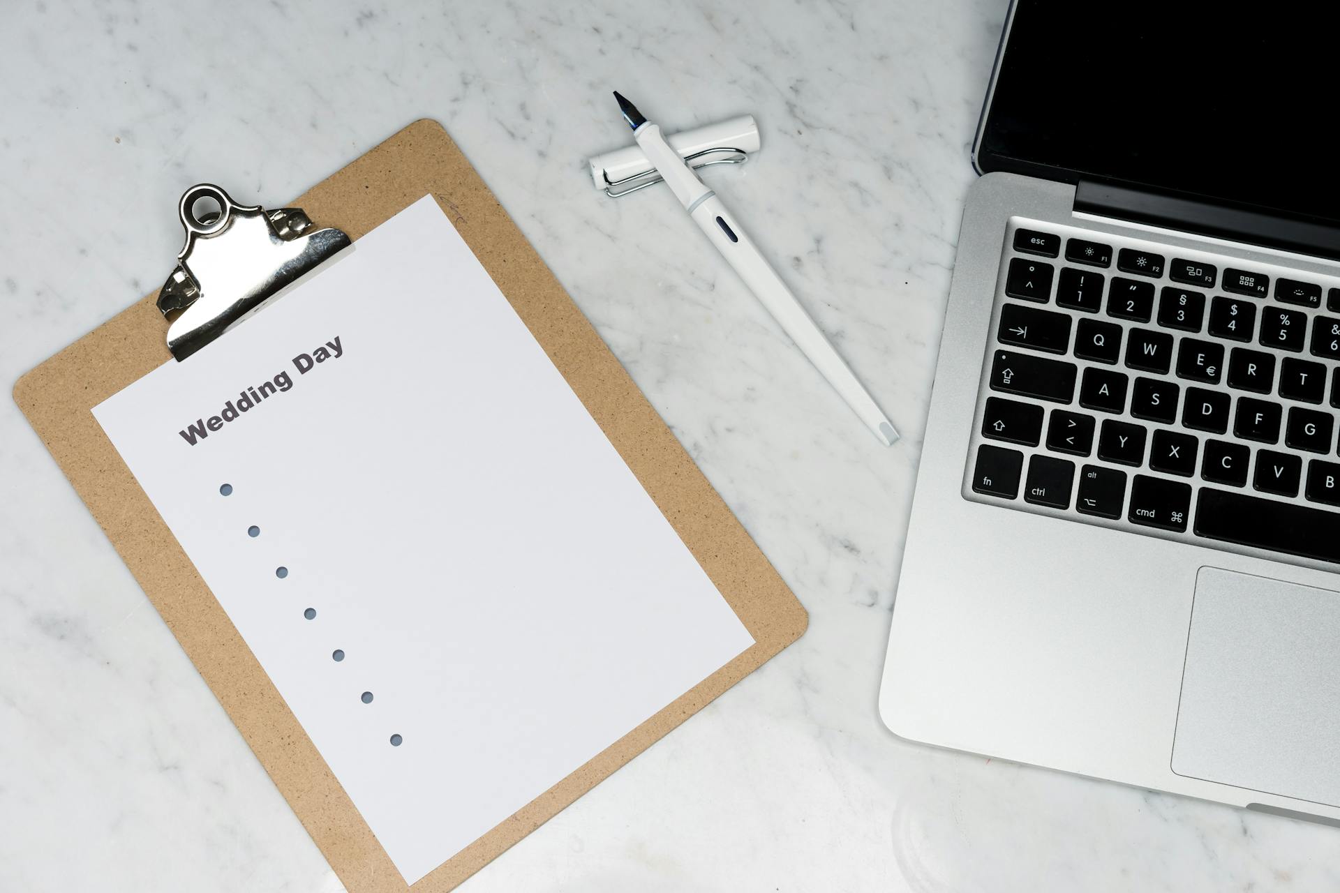 A wedding planner's laptop and notebook | Source: Pexels
