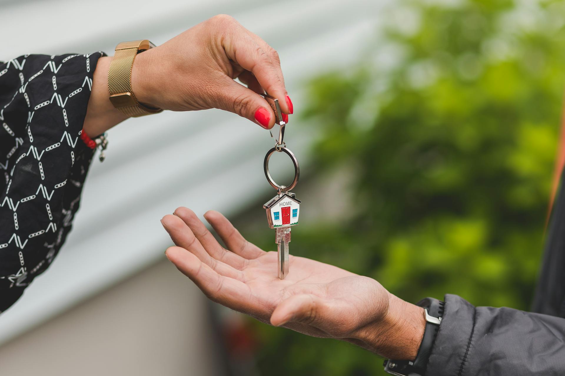 A woman handing house keys to a man | Source: Pexels