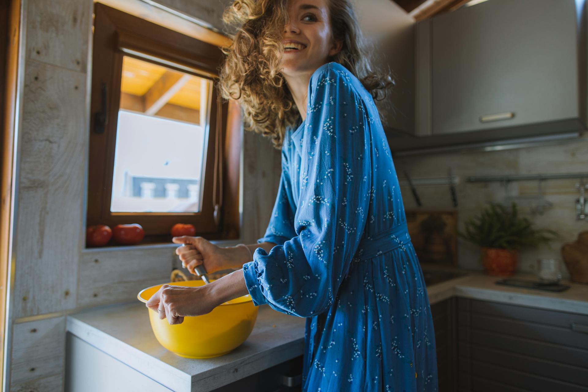 A smiling woman cooking | Source: Pexels