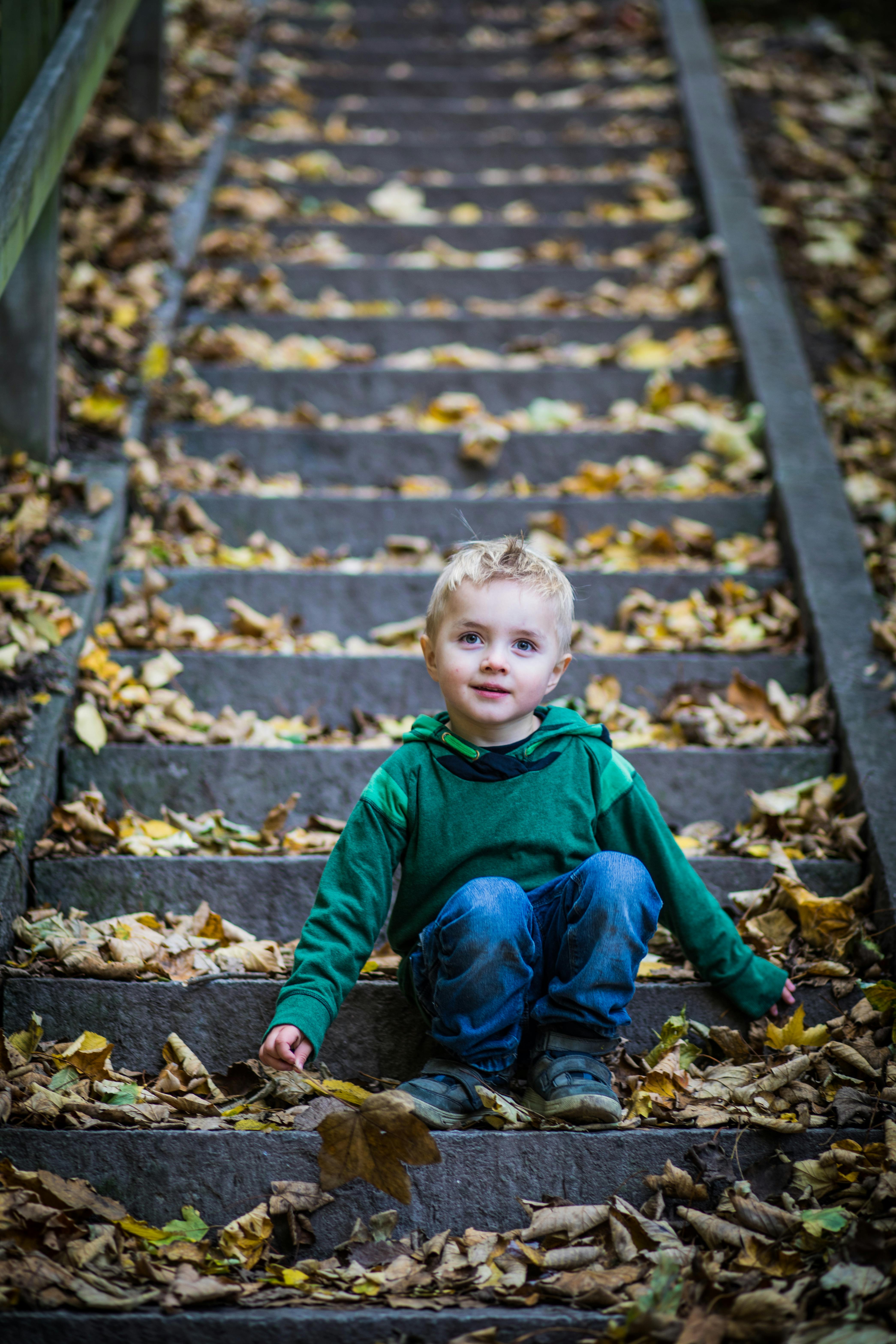 A little boy sitting on stairs | Source: Pexels