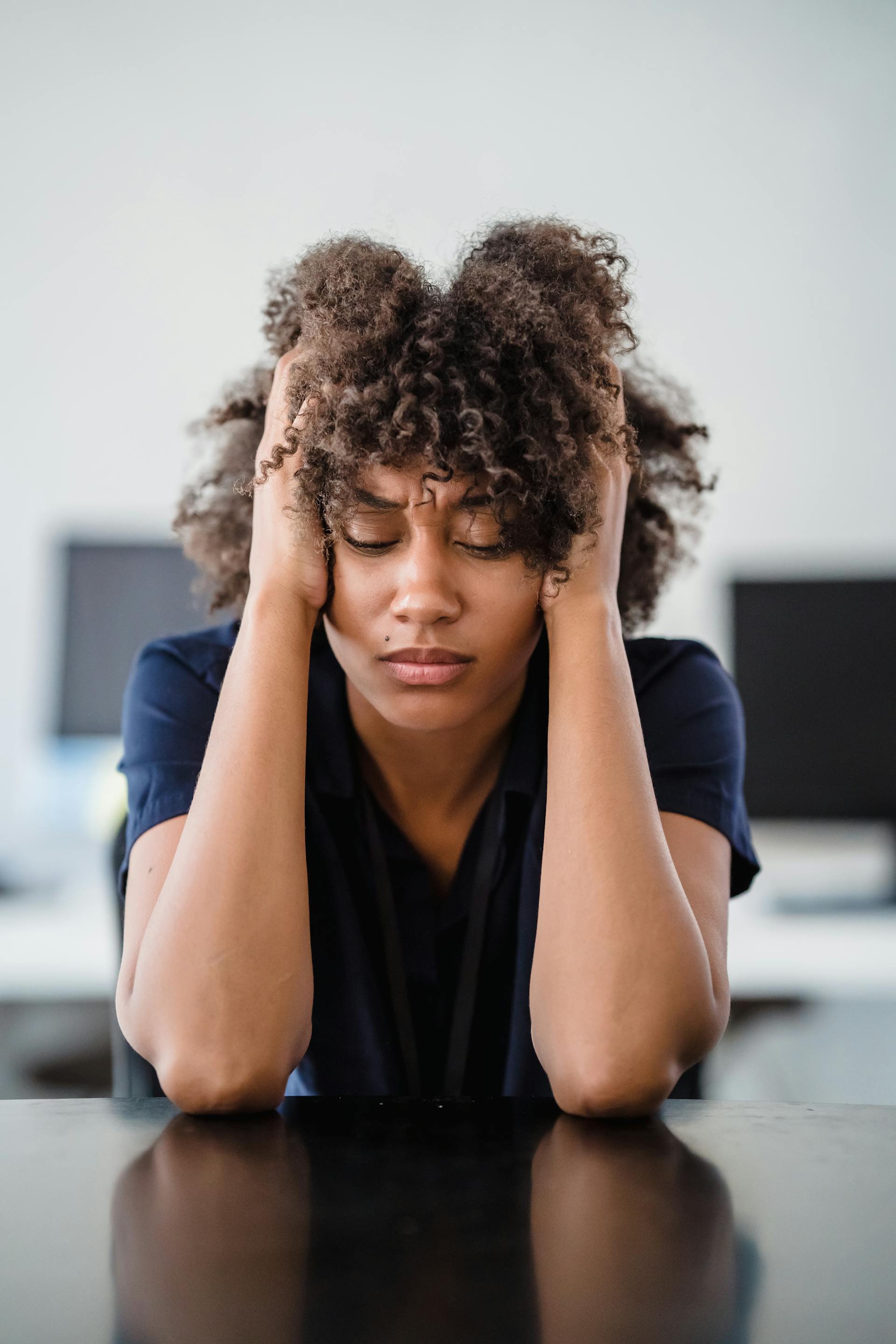 A woman with her head in her hands | Source: Pexels
