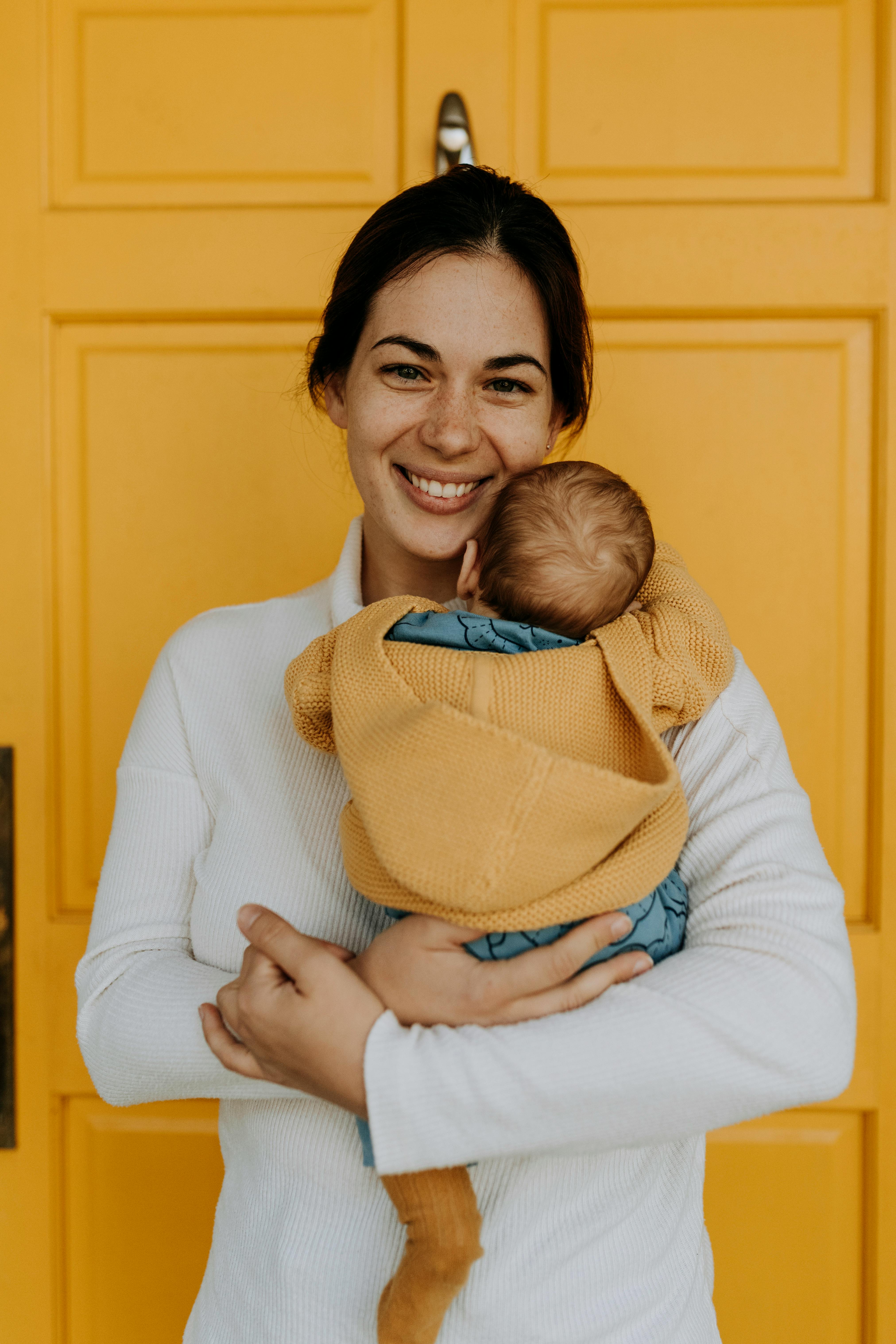 A woman carrying a baby | Source: Pexels