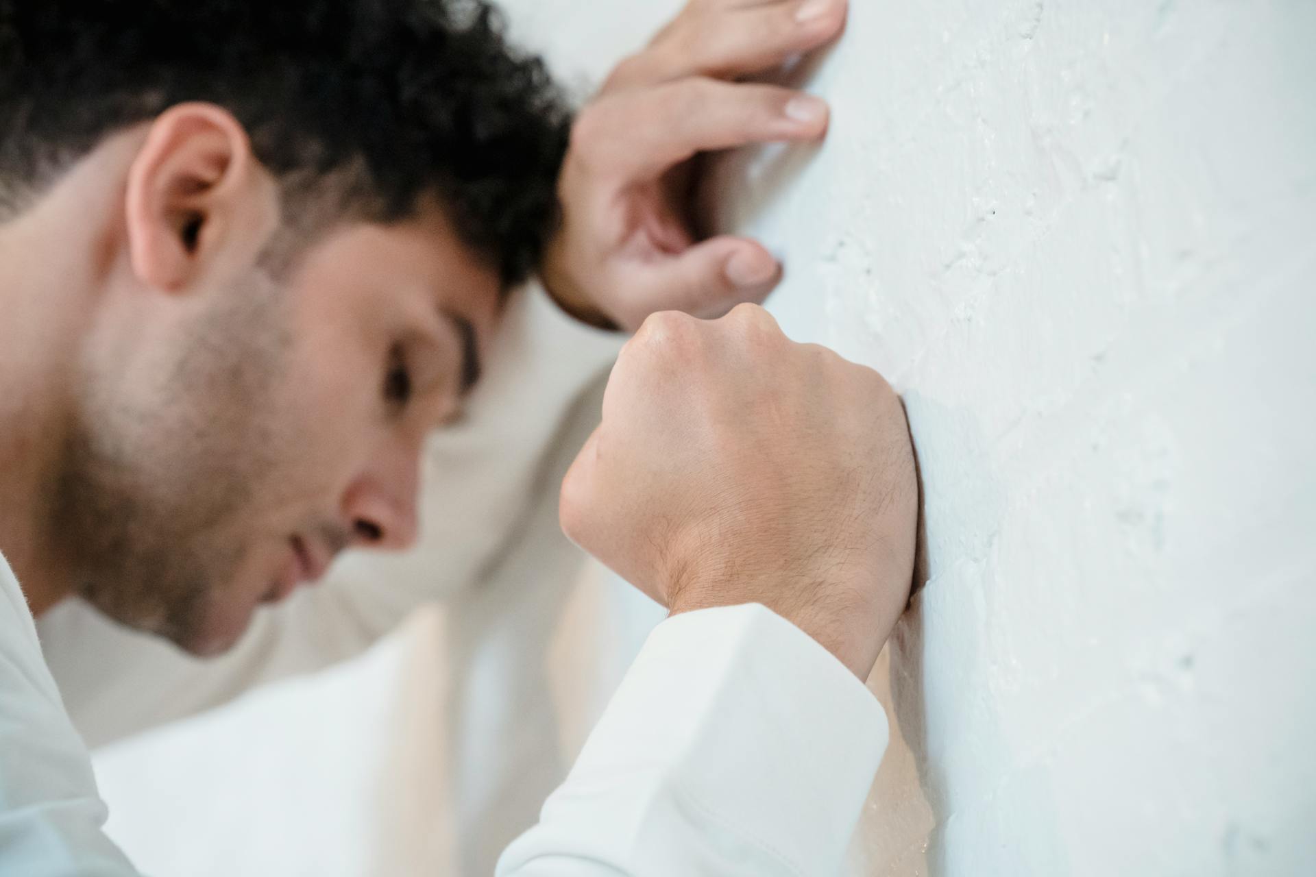 A frustrated man leaning on the wall | Source: Pexels