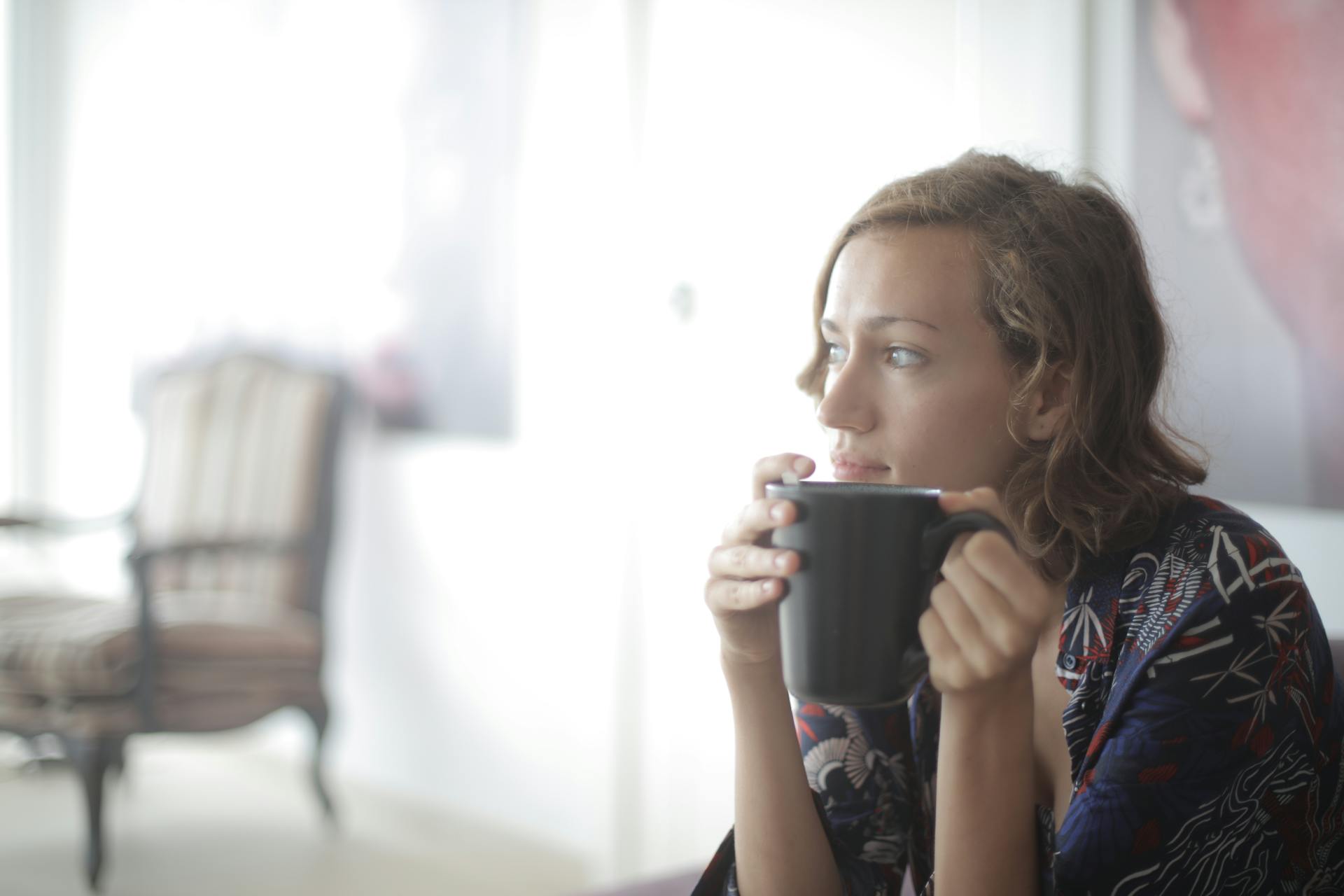 A woman having a warm drink in a living room | Source: Pexels