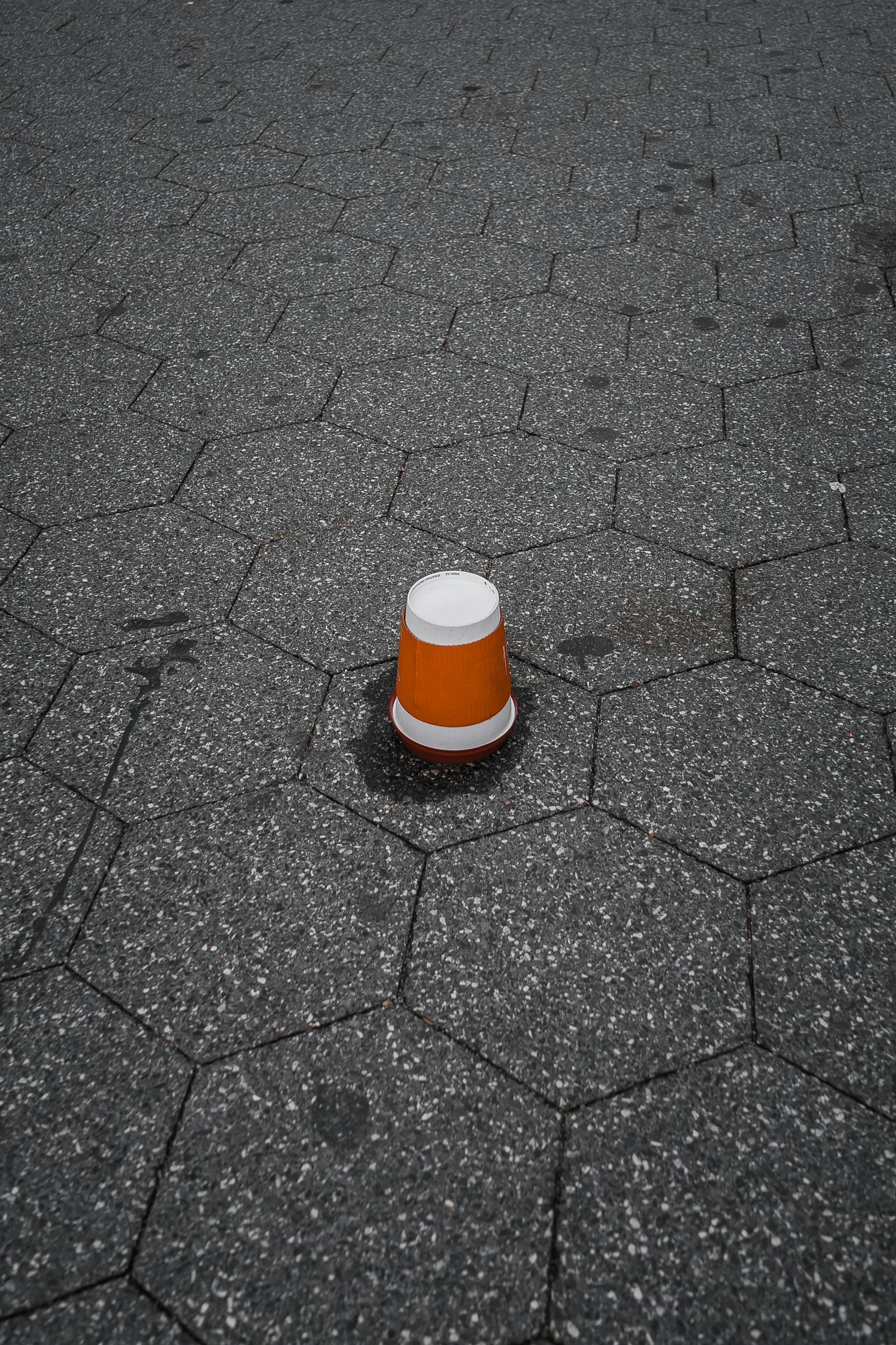 A plastic cup lying upside down on a pavement | Source: Pexels