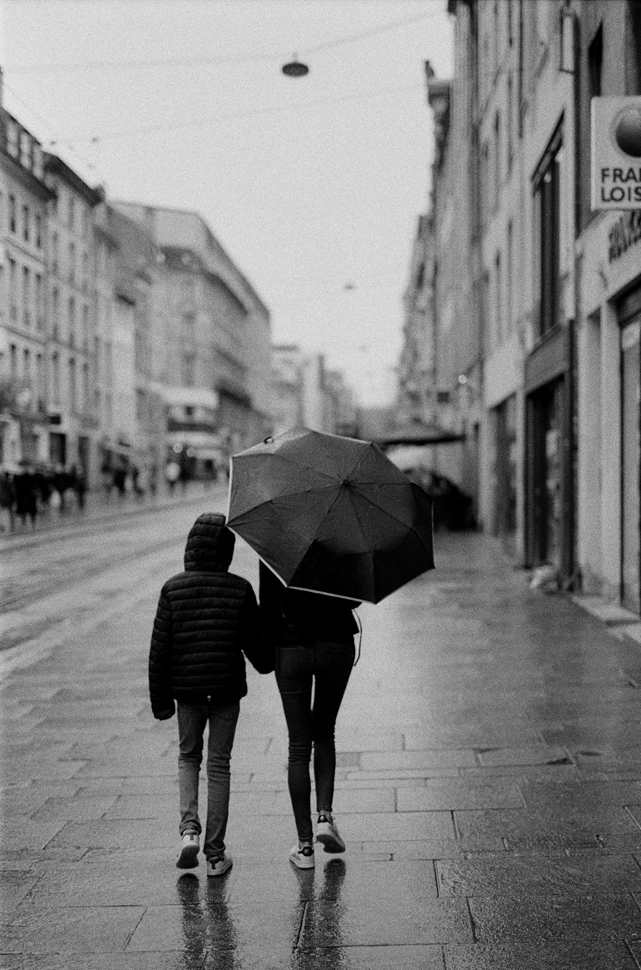 Grayscale shot of a mother walking with her child | Source: Pexels