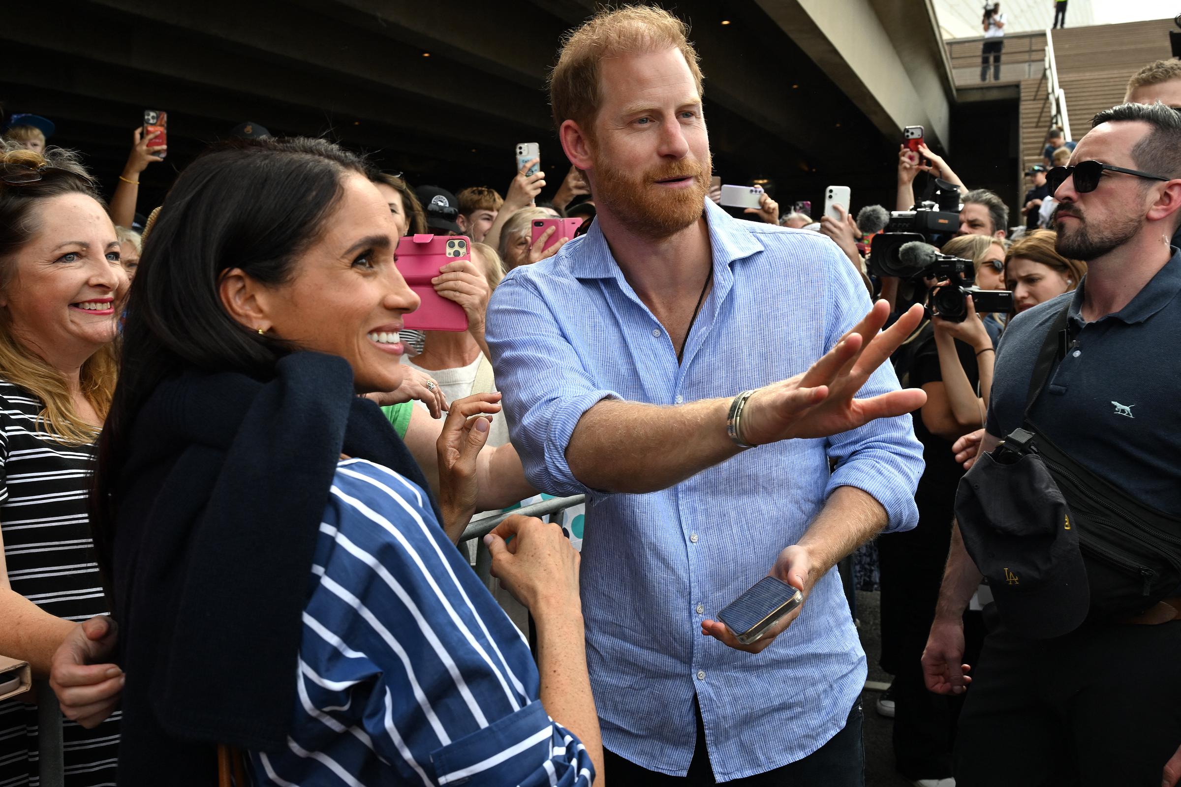 Prince Harry, Duke of Sussex, and his wife Meghan, Duchess of Sussex, meet with members of the public beneath the steps of Australia's iconic Sydney Opera House on April 17, 2026. | Source: Getty Images
