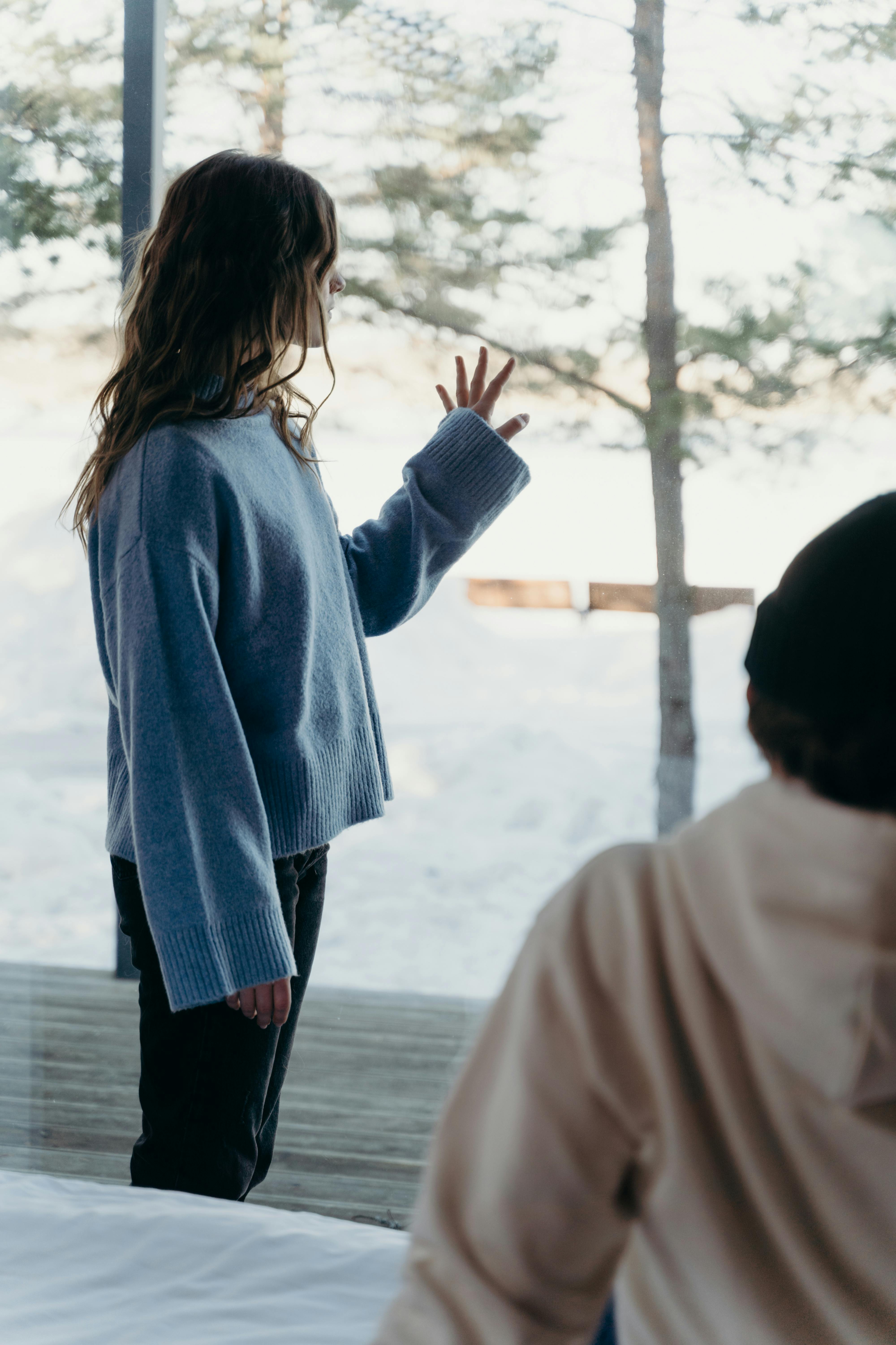 A man looking at a woman standing by the window | Source: Pexels
