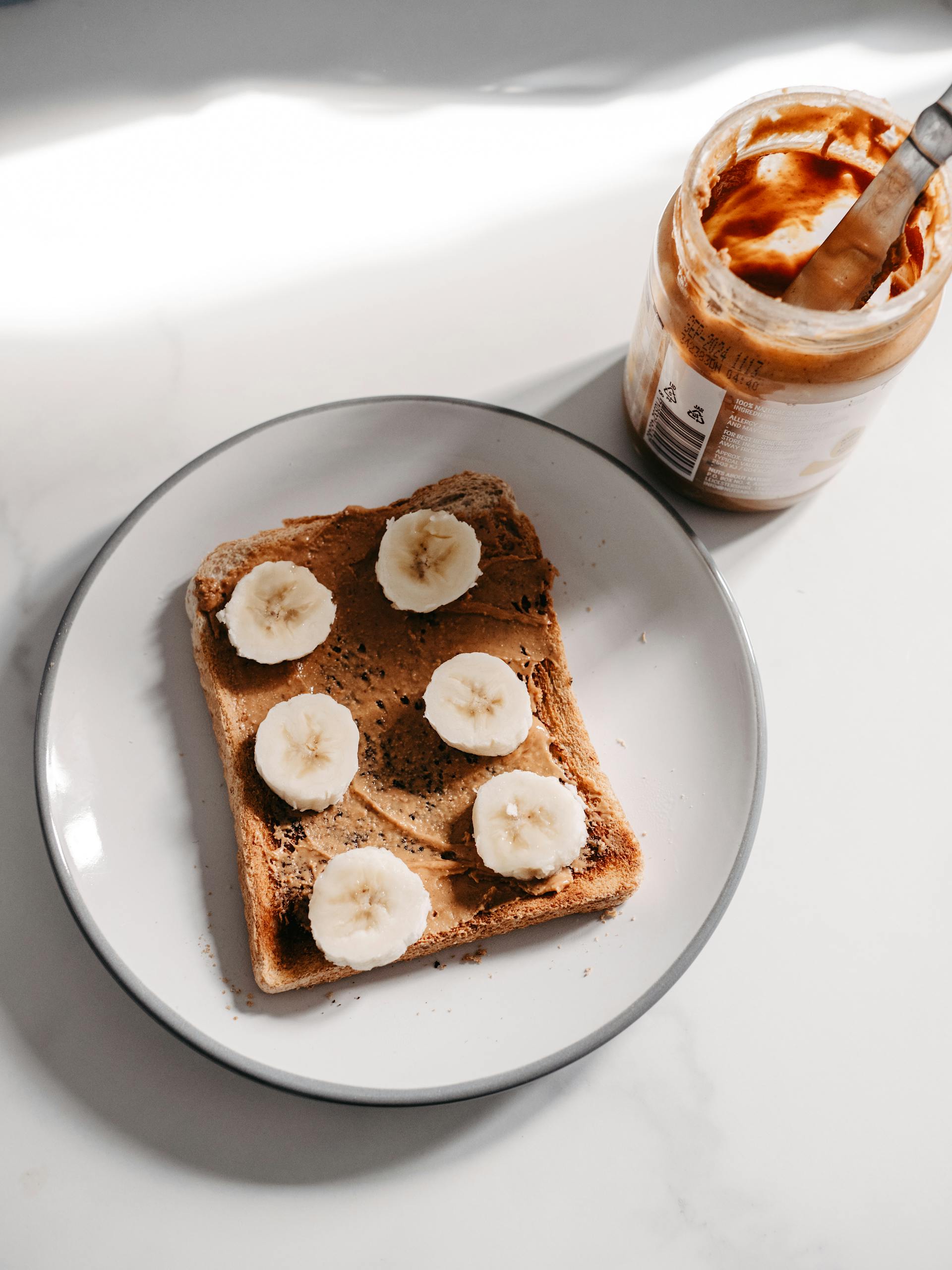 An open jar of peanut butter and bread | Source: Pexels