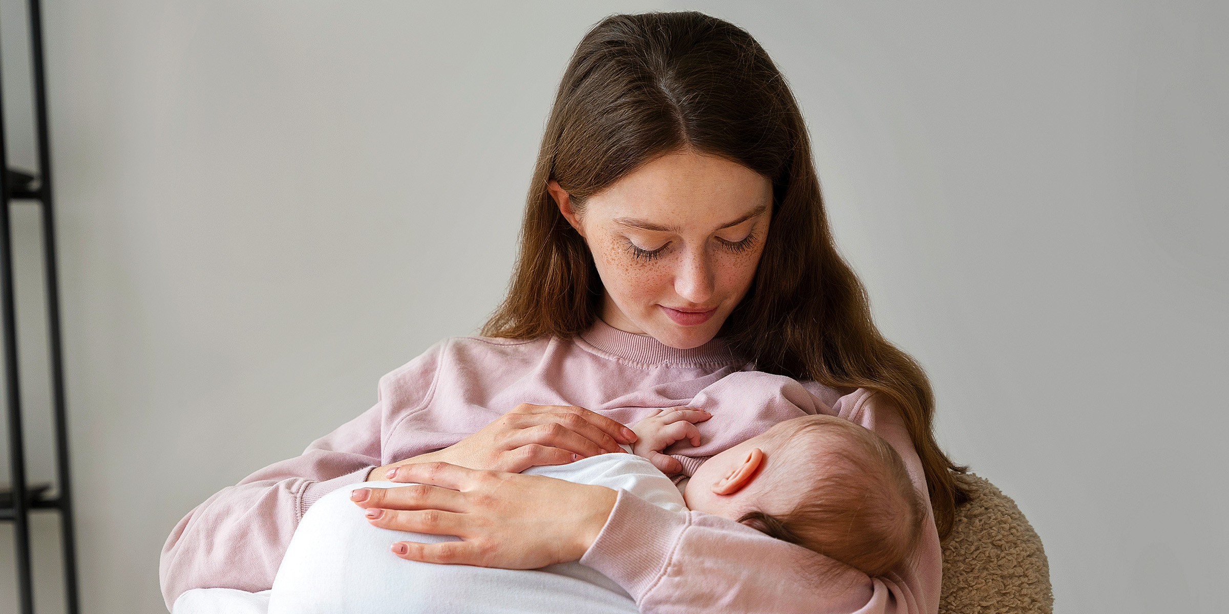 A young woman feeding her baby | Source: Freepik