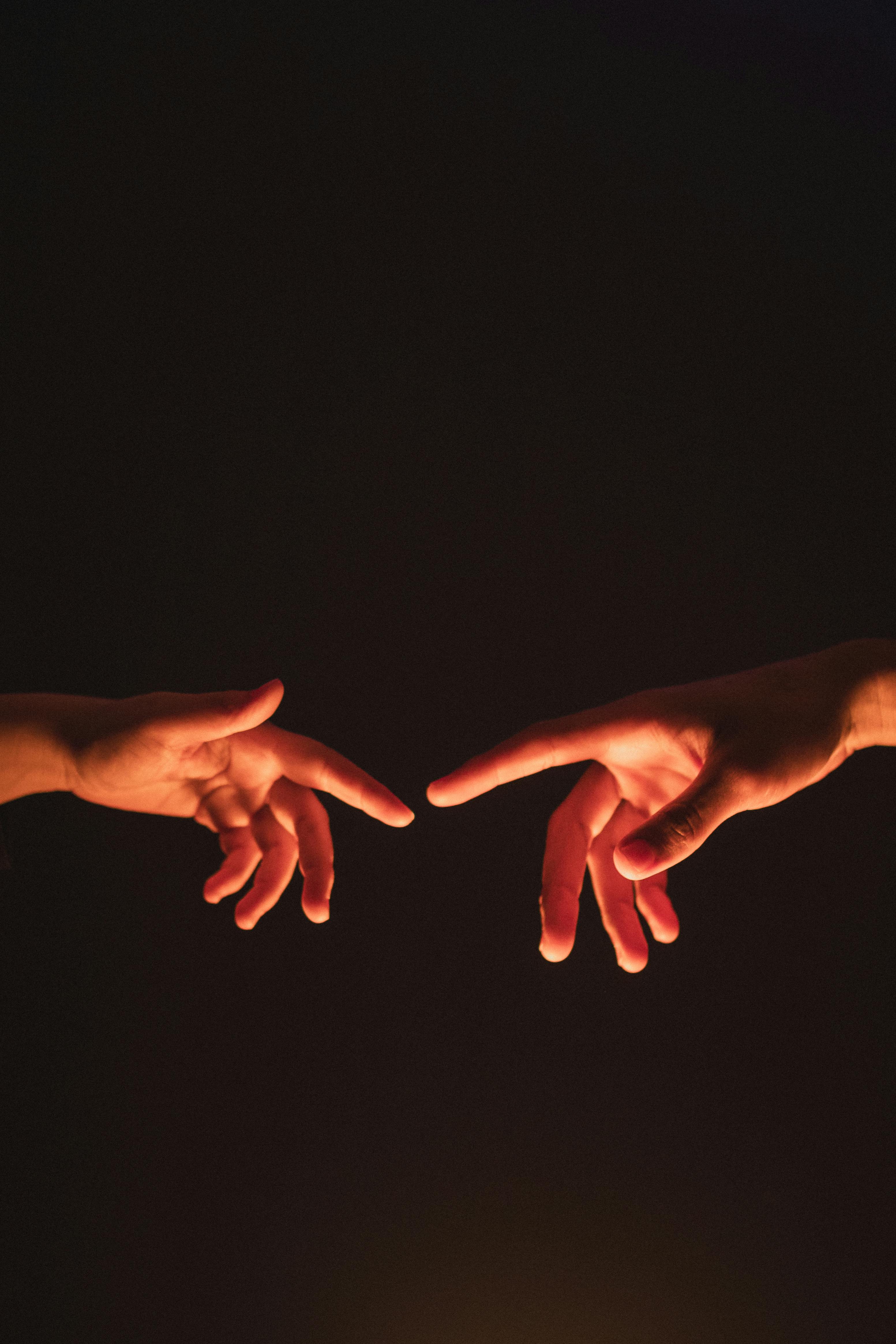 Two people reaching for each other's hands | Source: Pexels