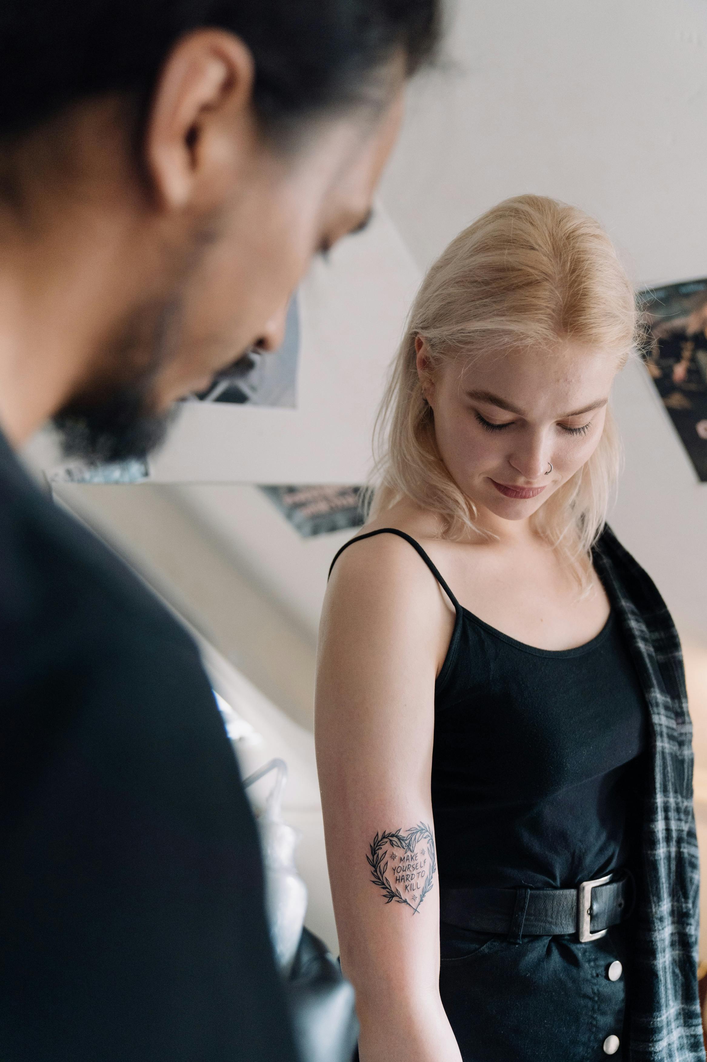 Curious man observing a woman's tattoo | Source: Pexels