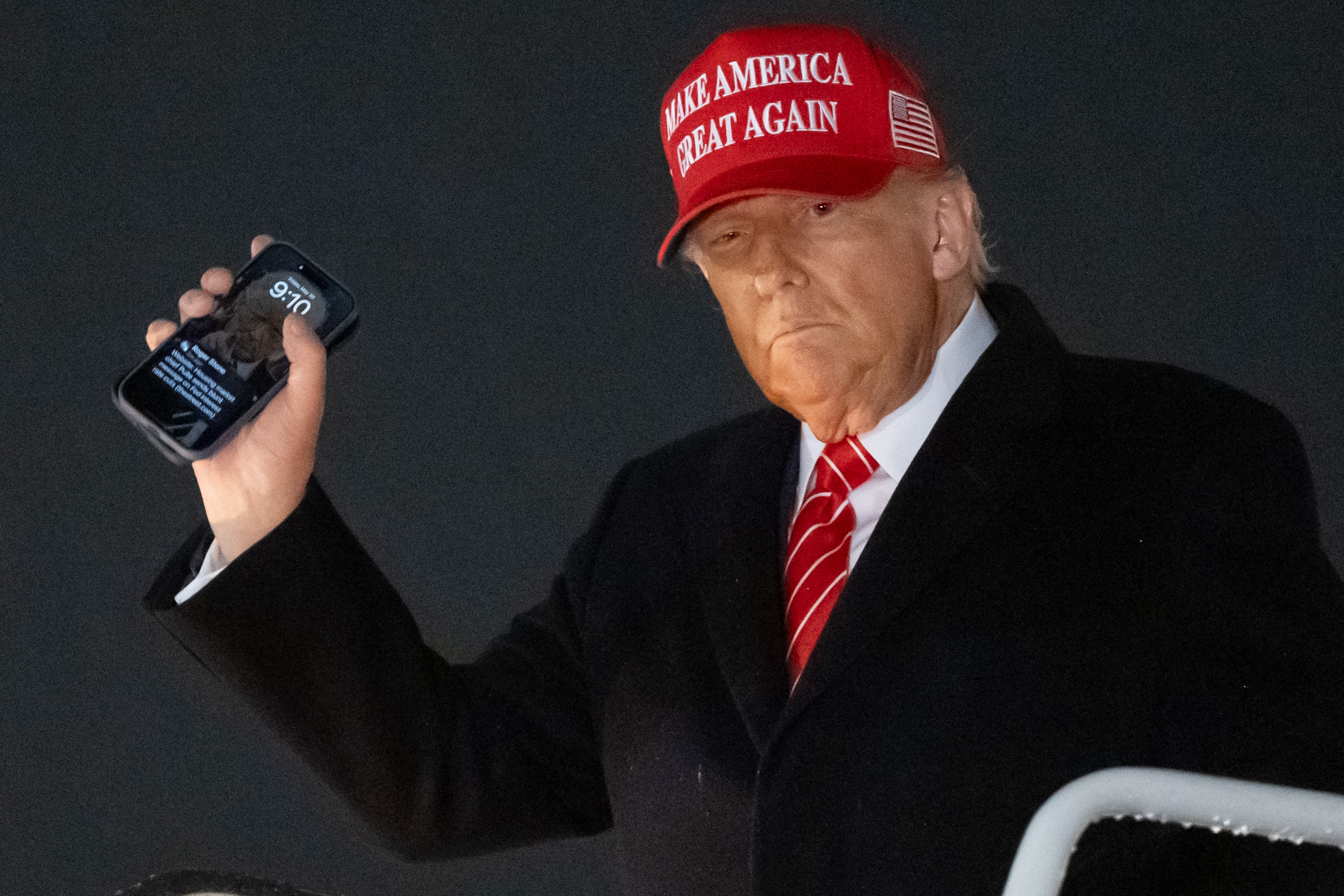 US President Donald Trump disembarks from Air Force One while holding his cellphone with a text message from Roger Stone upon arrival at Joint Base Andrews in Maryland, May 30, 2025 | Source: Getty Images