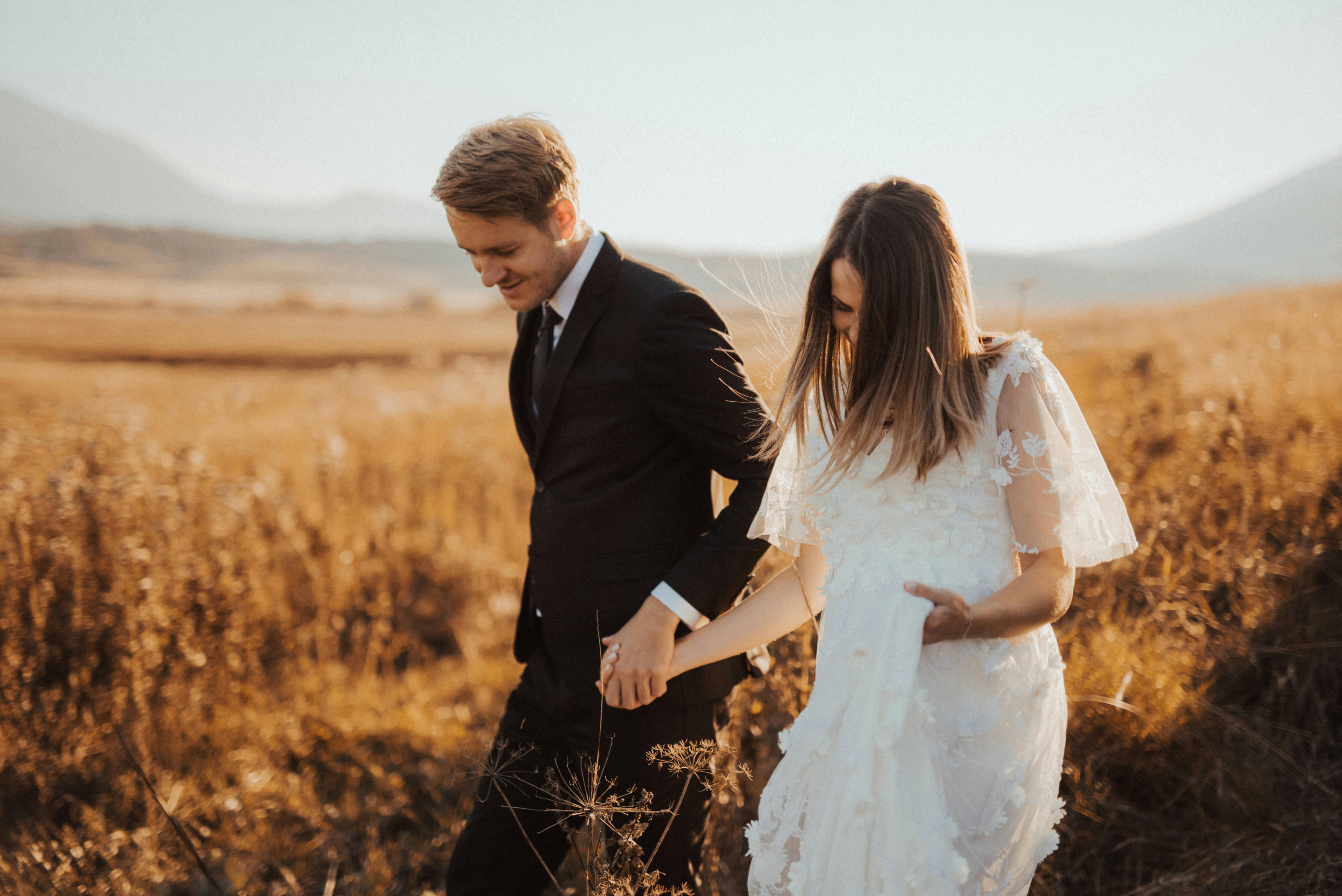 A bridal couple in a field | Source: Pexels