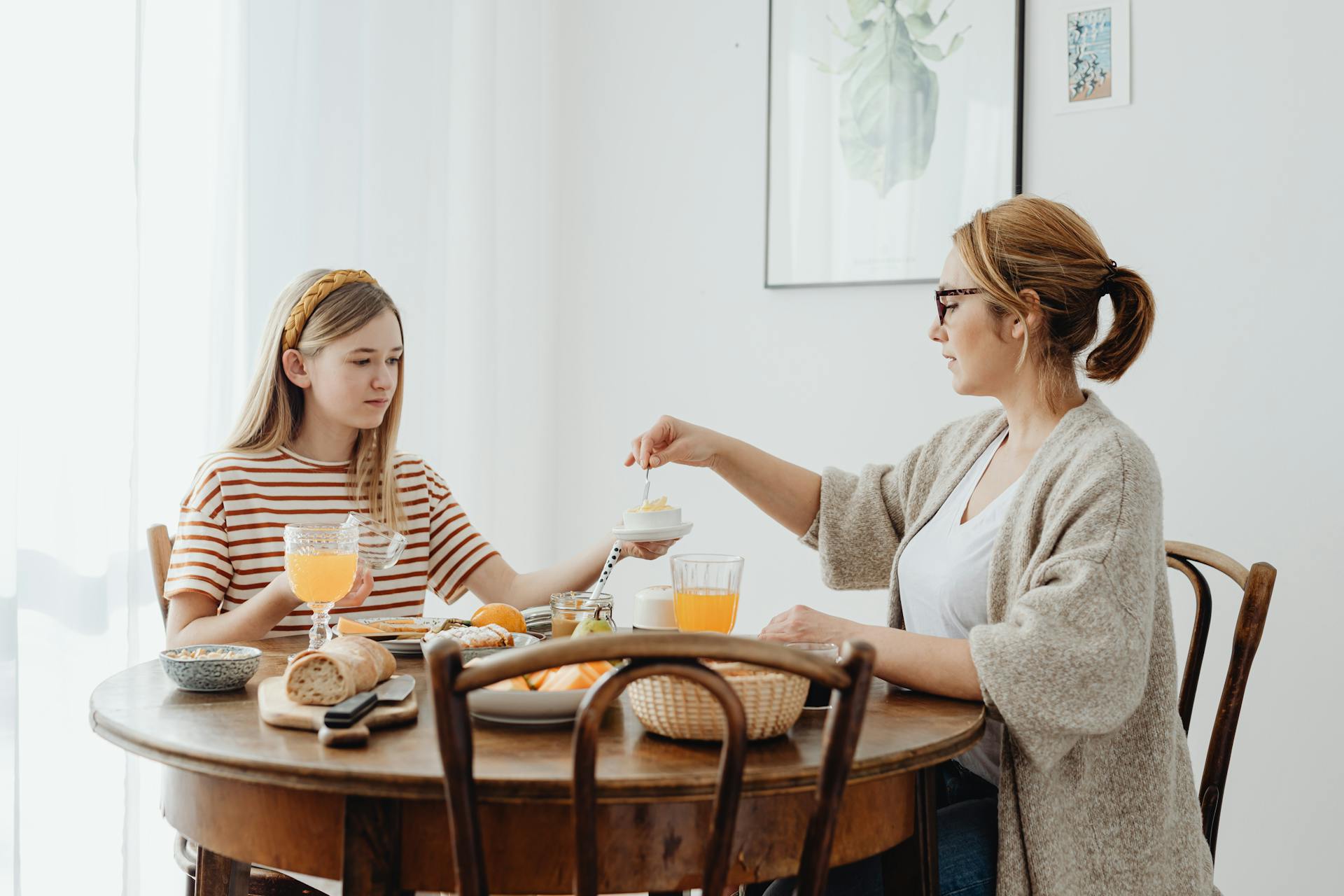 A woman and a teenage girl seated at the dining table | Source: Pexels