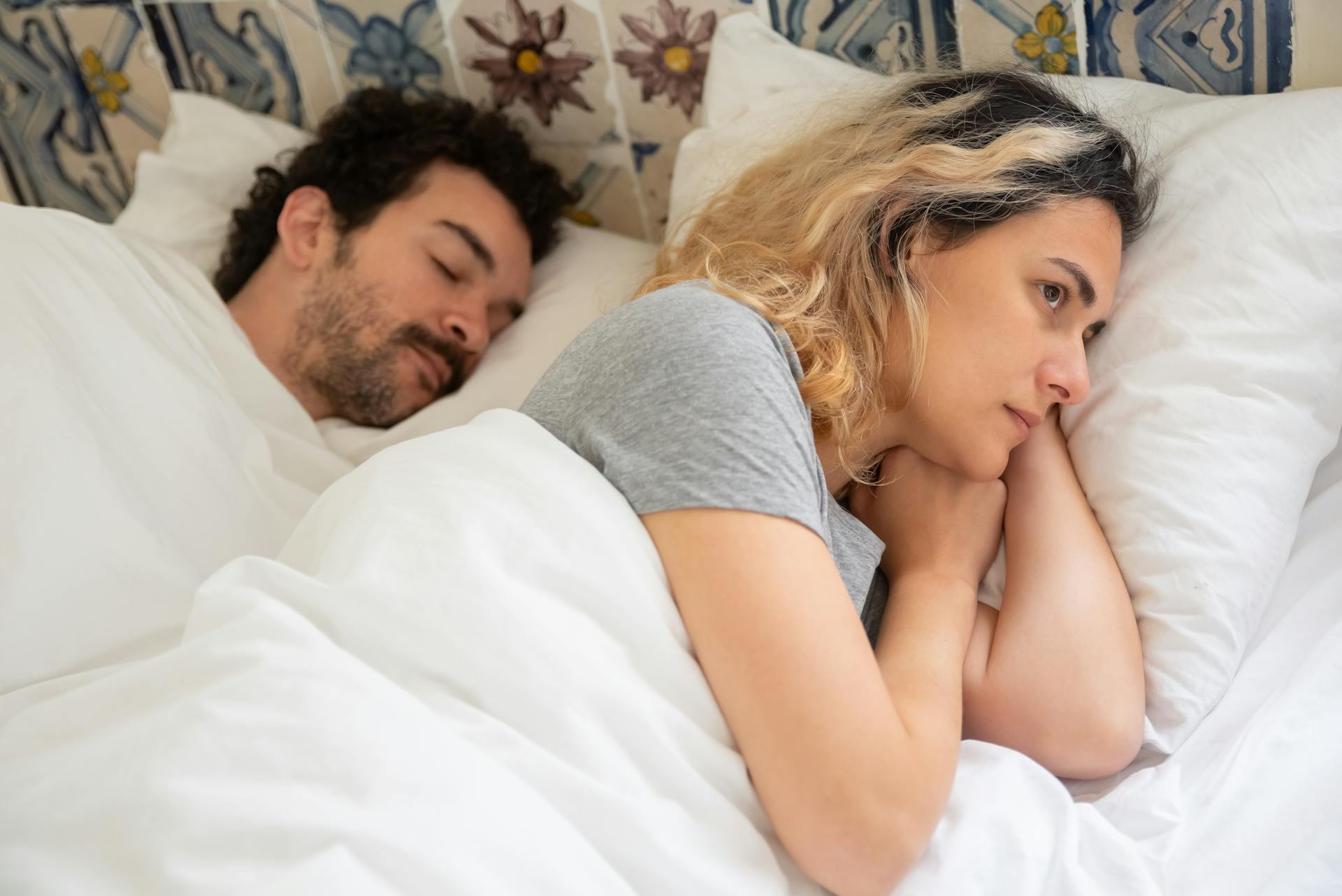 A contemplative woman lying awake in bed | Source: Pexels