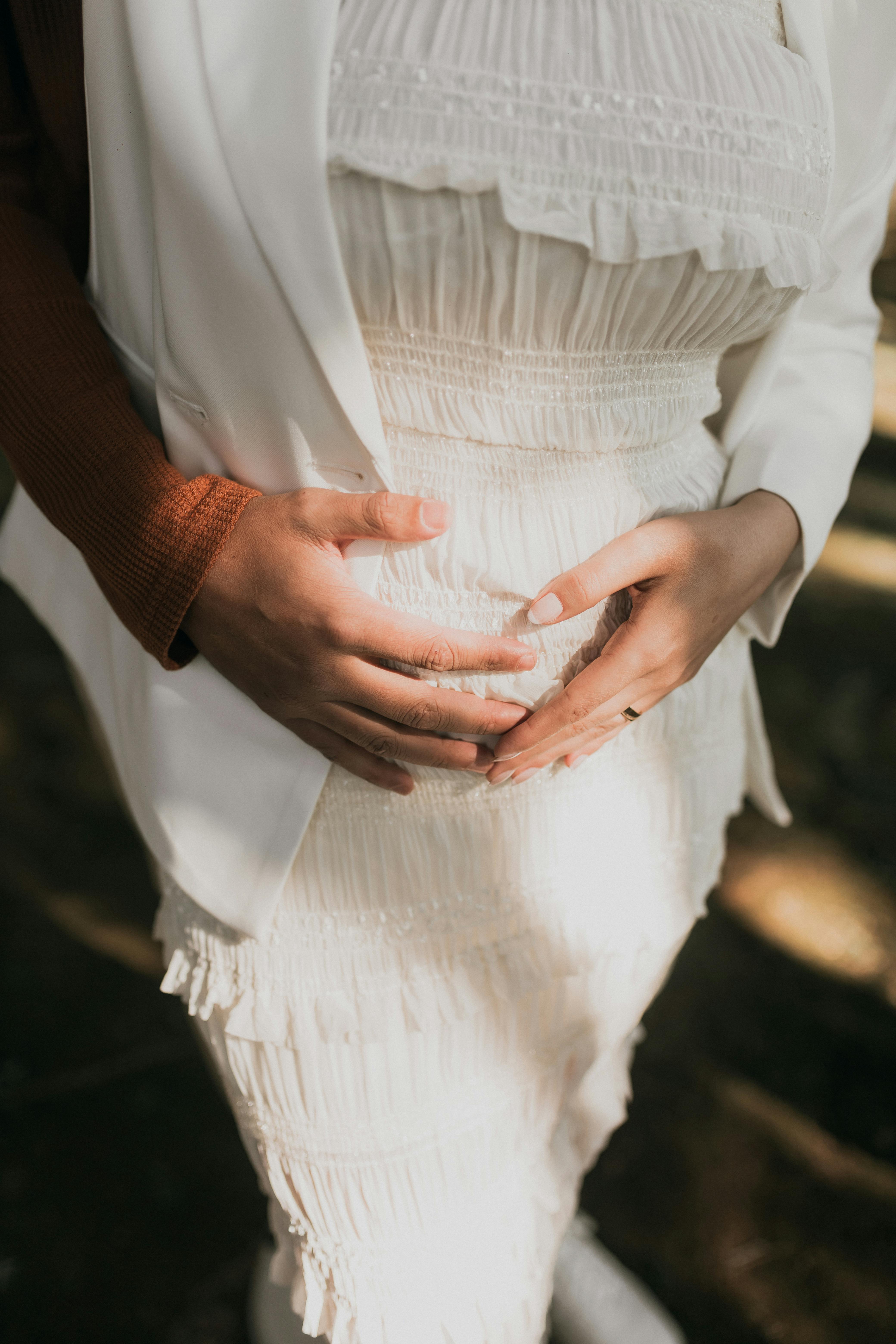 A couple holding a pregnant belly | Source: Pexels