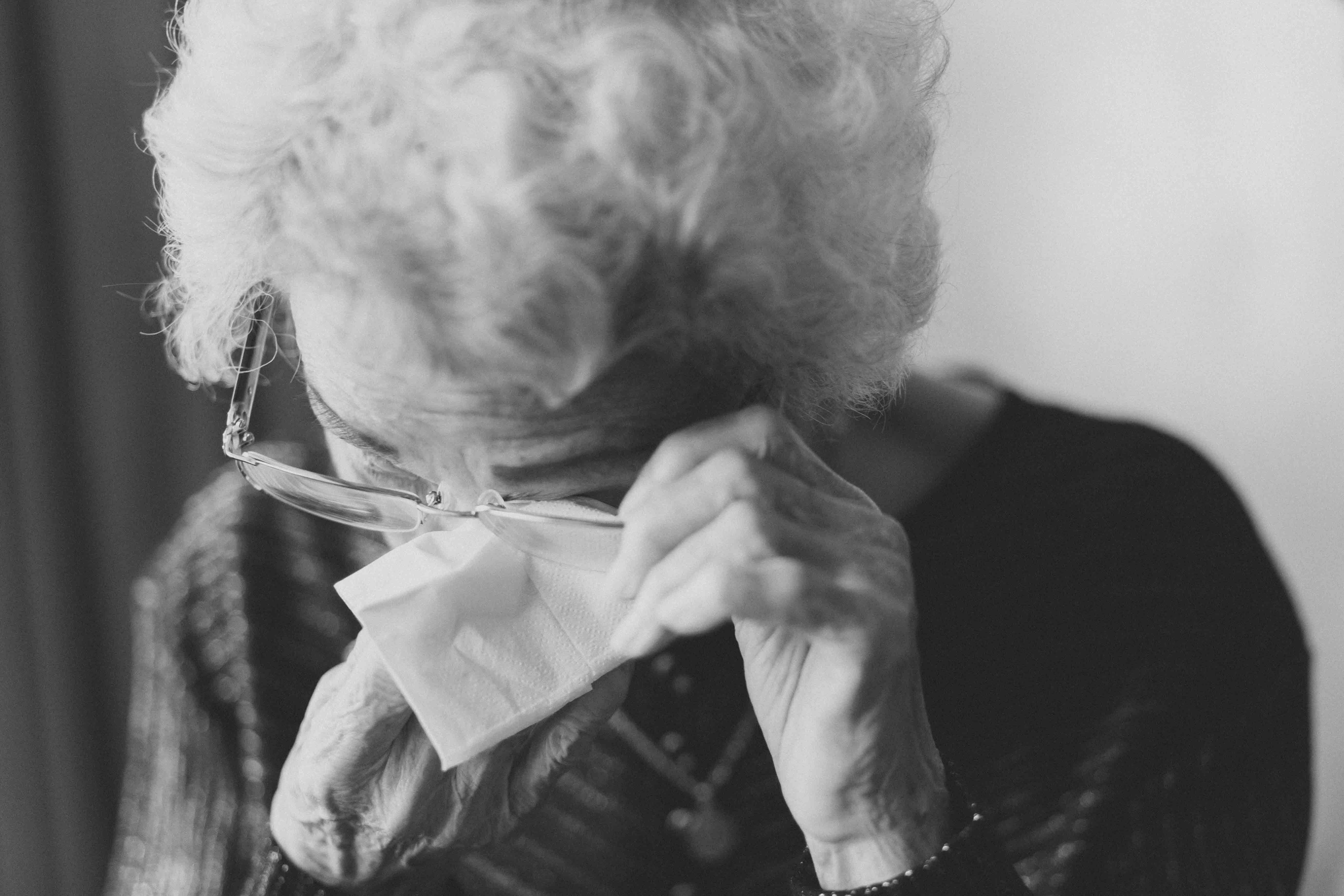 An old woman wiping her eyes | Source: Unsplash