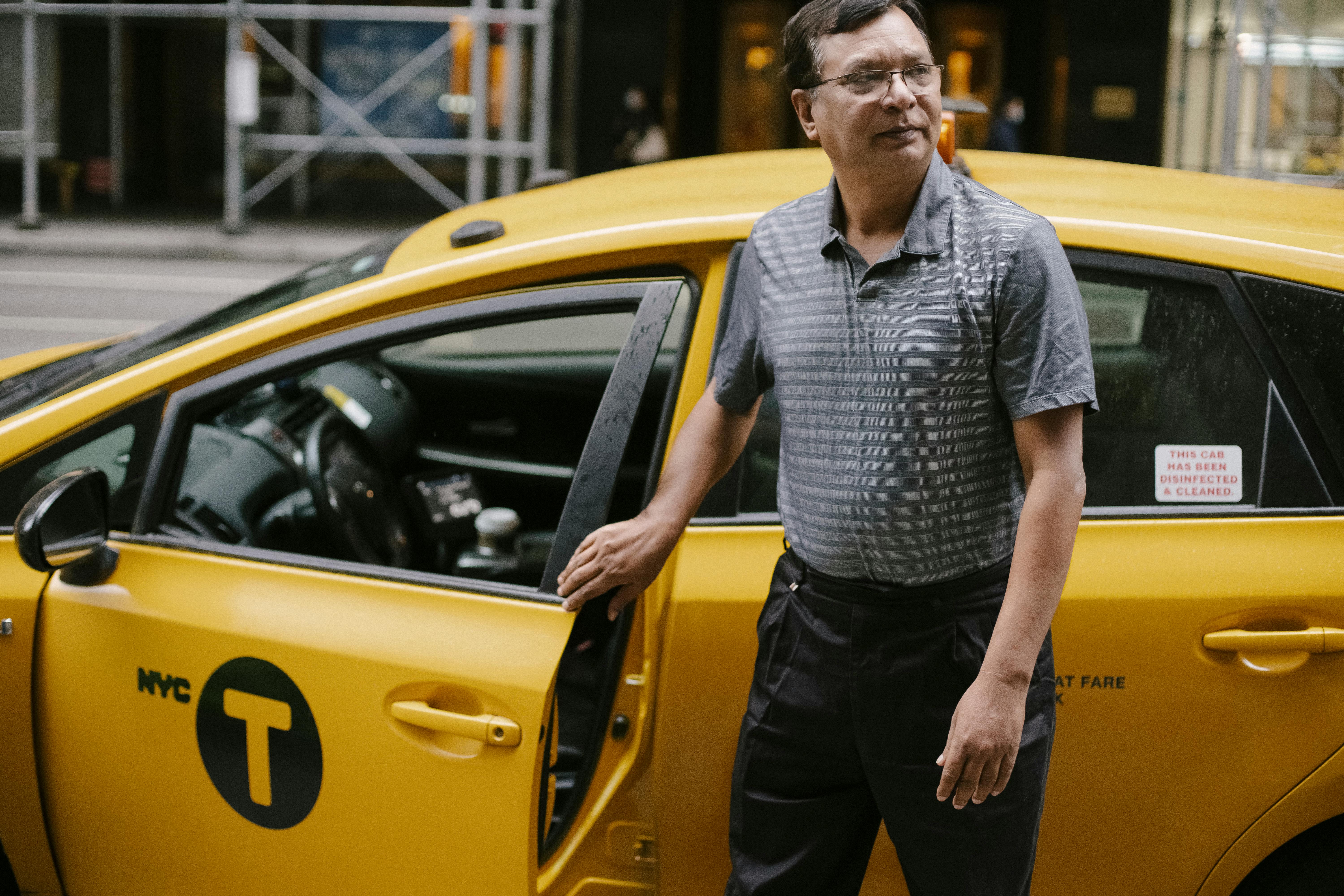 A taxi driver standing next to his car | Source: Pexels
