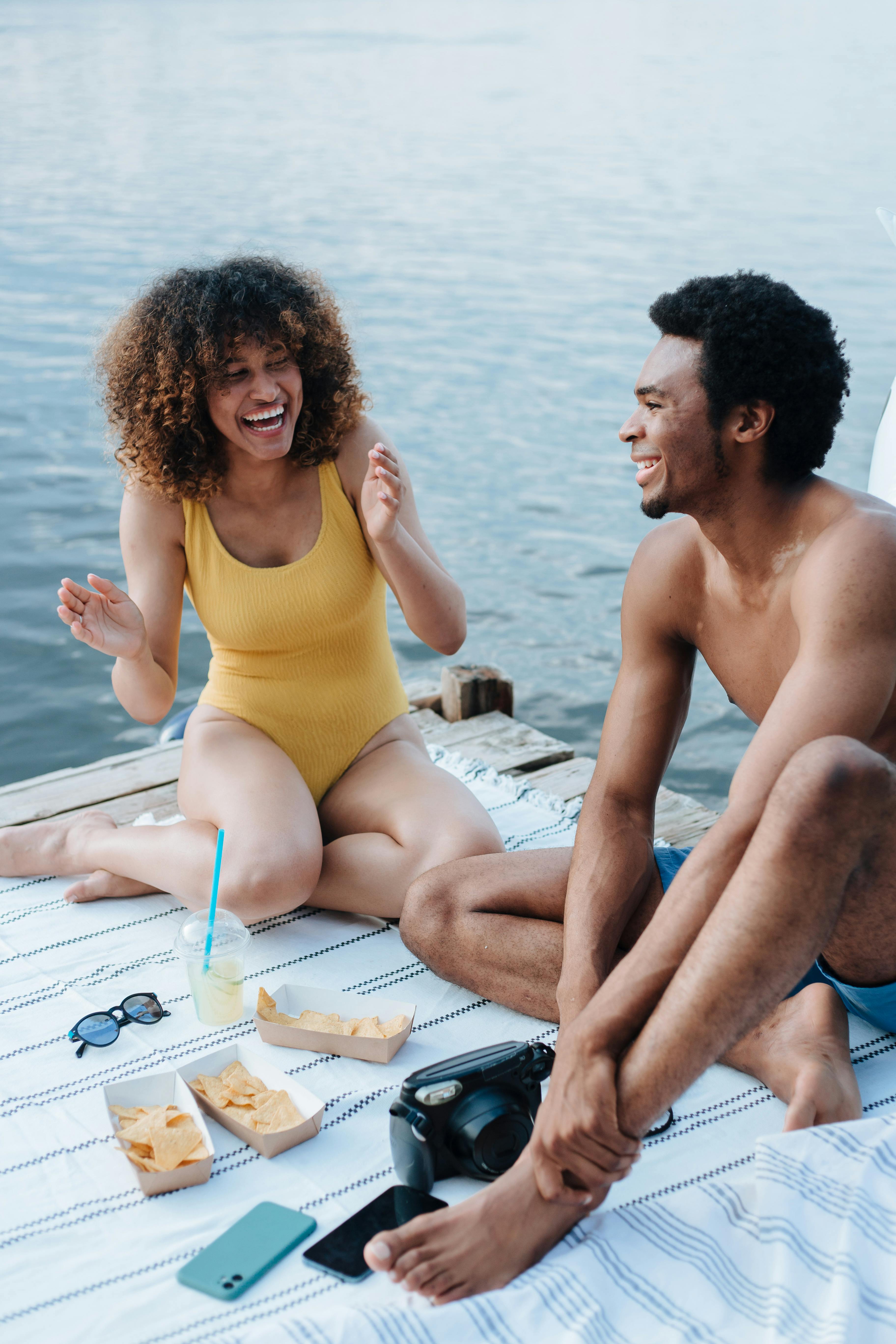 Couple laughing by the water | Source: Pexels