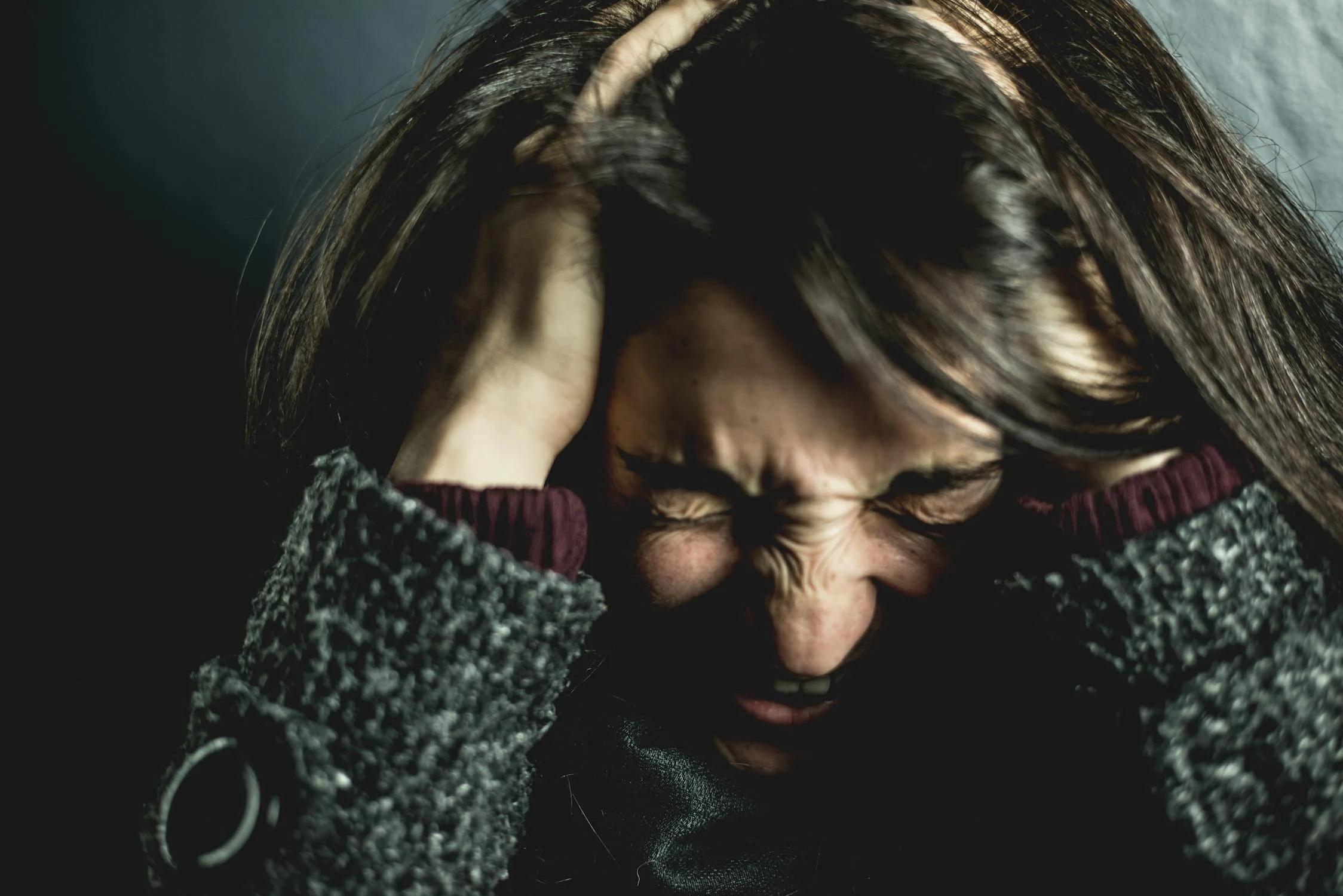 An angry woman rubbing her head | Source: Pexels