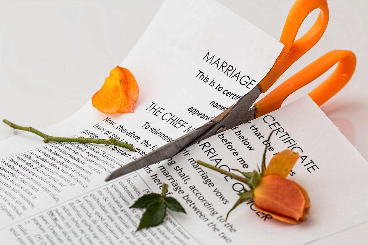 A scissor cutting through a marriage certificate | Source: Pixabay