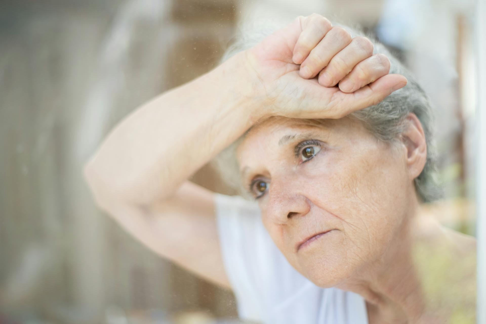 A woman looking through a window | Source: Pexels