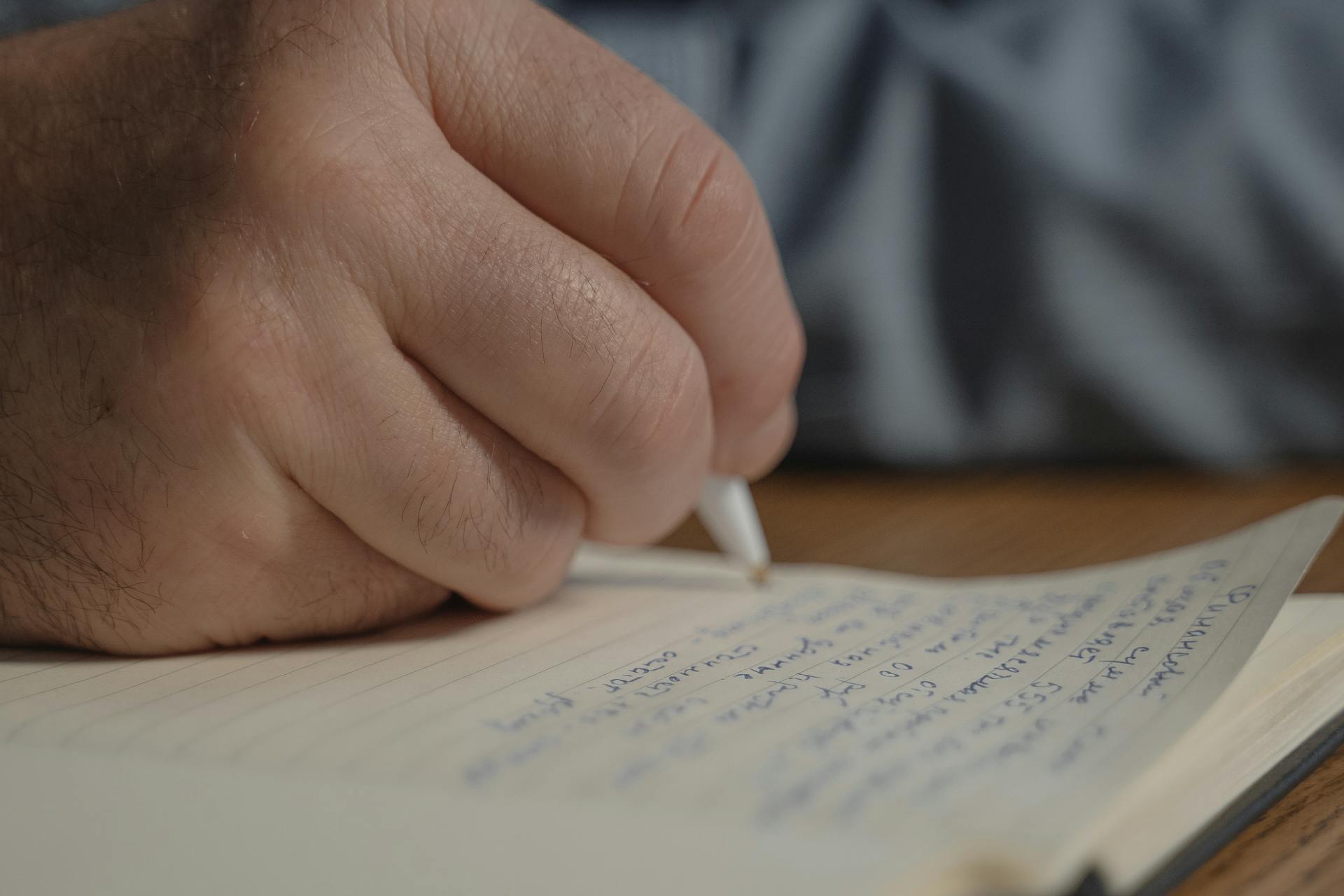 A person writing on paper | Source: Pexels