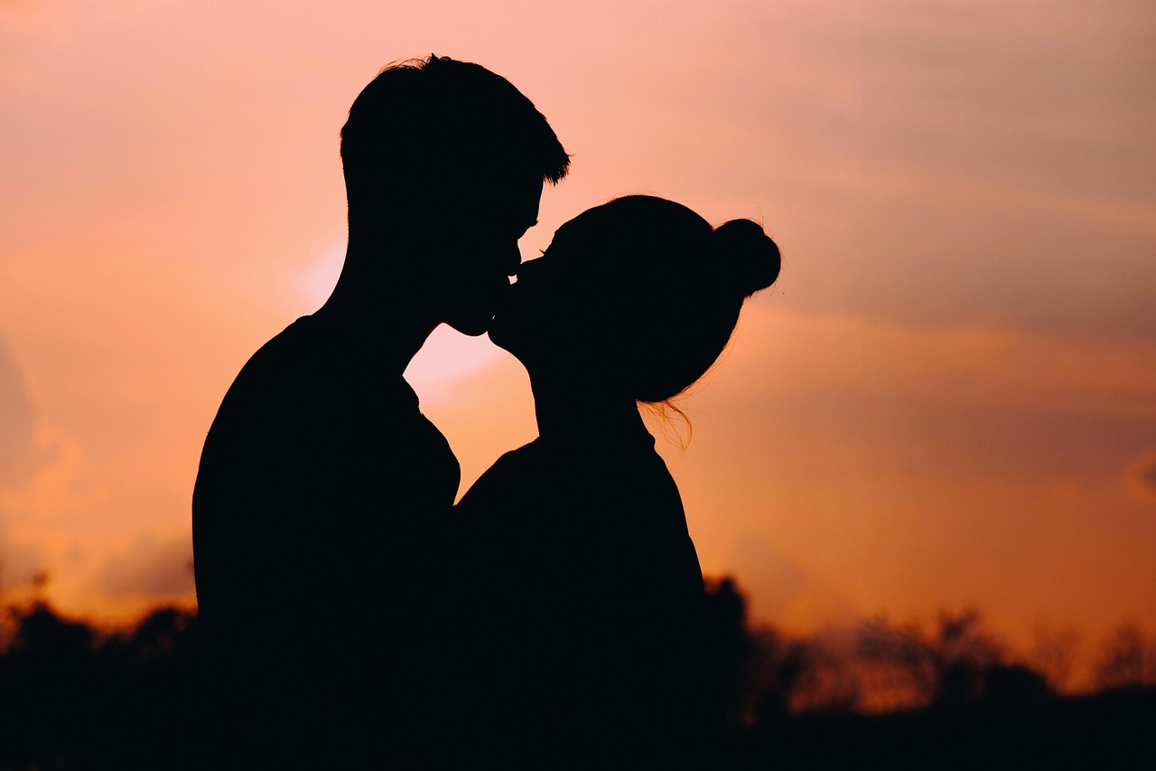 A silhouette of a couple sharing a kiss | Source: Pixabay