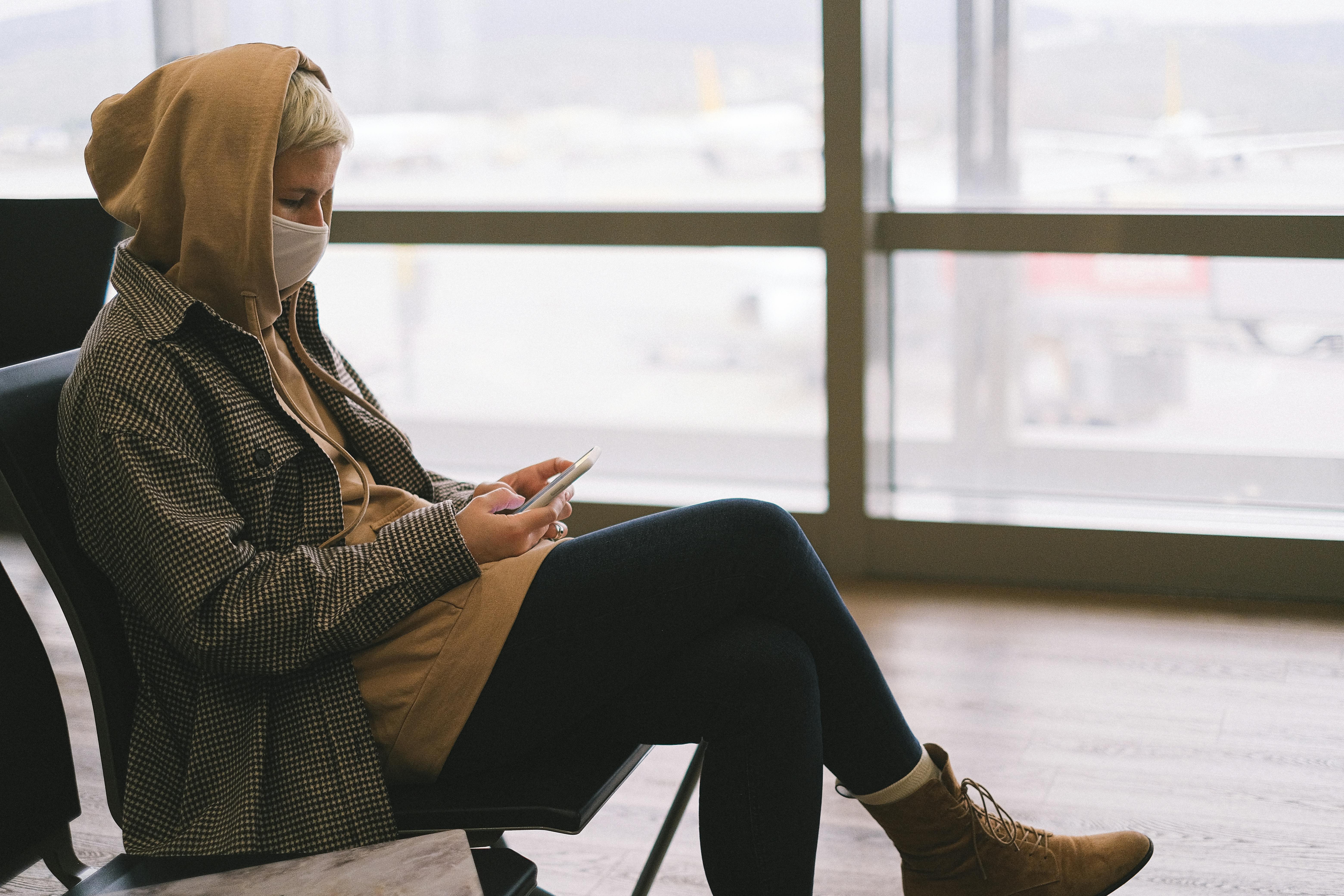 Une femme utilisant son téléphone à l'aéroport | Source : Pexels