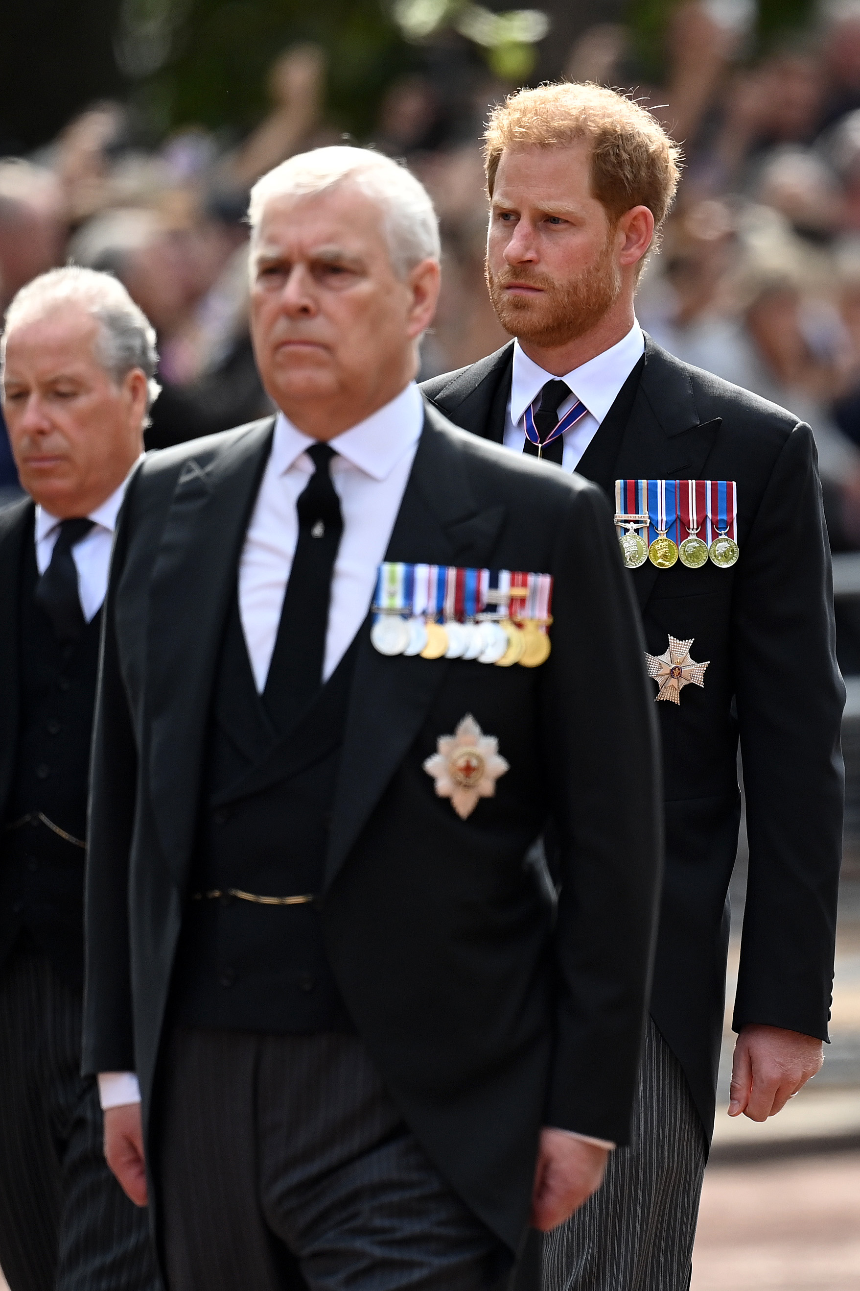 Prince Andrew, Duke of York and Prince Harry, Duke of Sussex walk behind the coffin during the procession for the Lying-in State of Queen Elizabeth II on September 14, 2022 in London, England. | Source: Getty Images