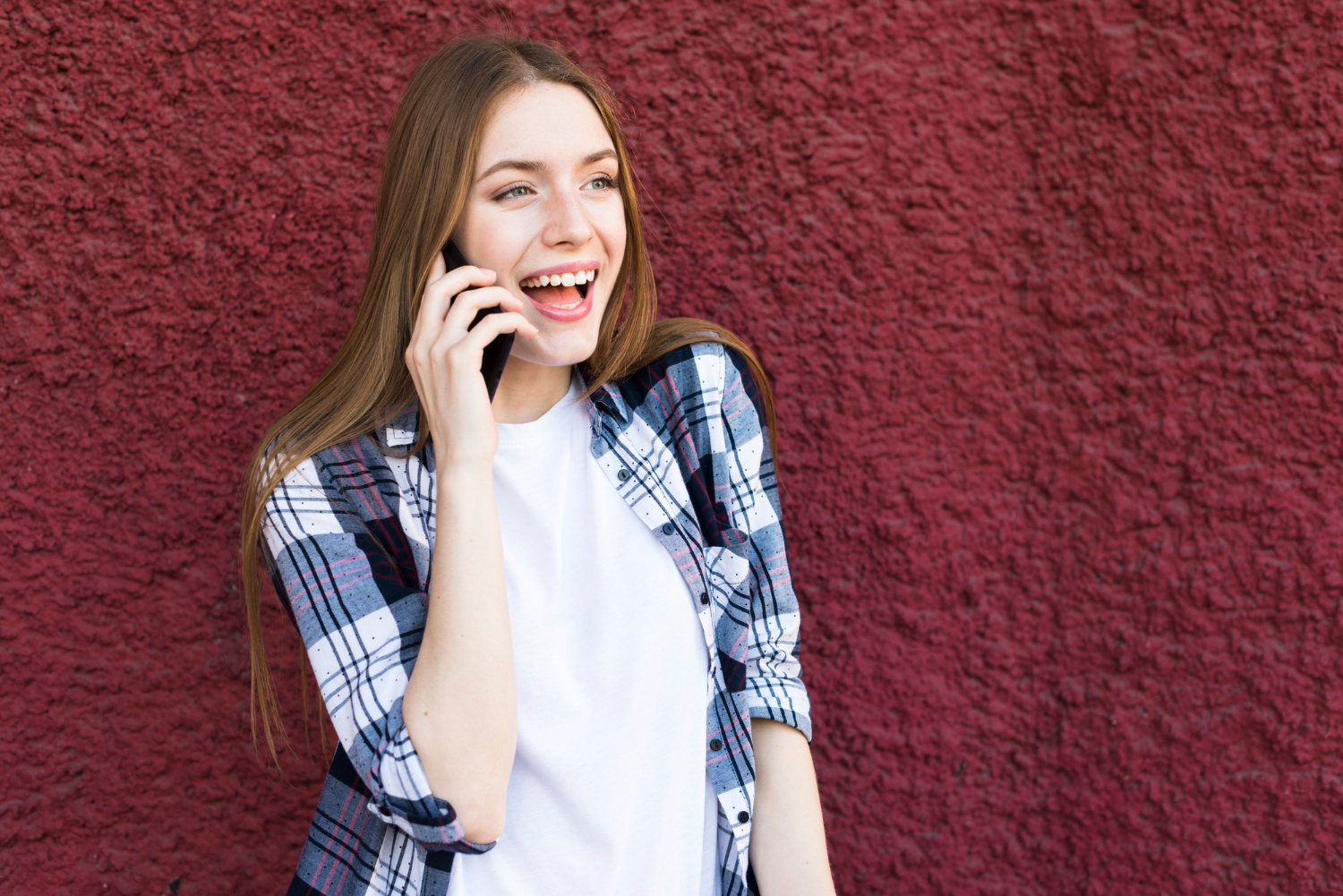 A cheerful woman talking on the phone | Source: Freepik